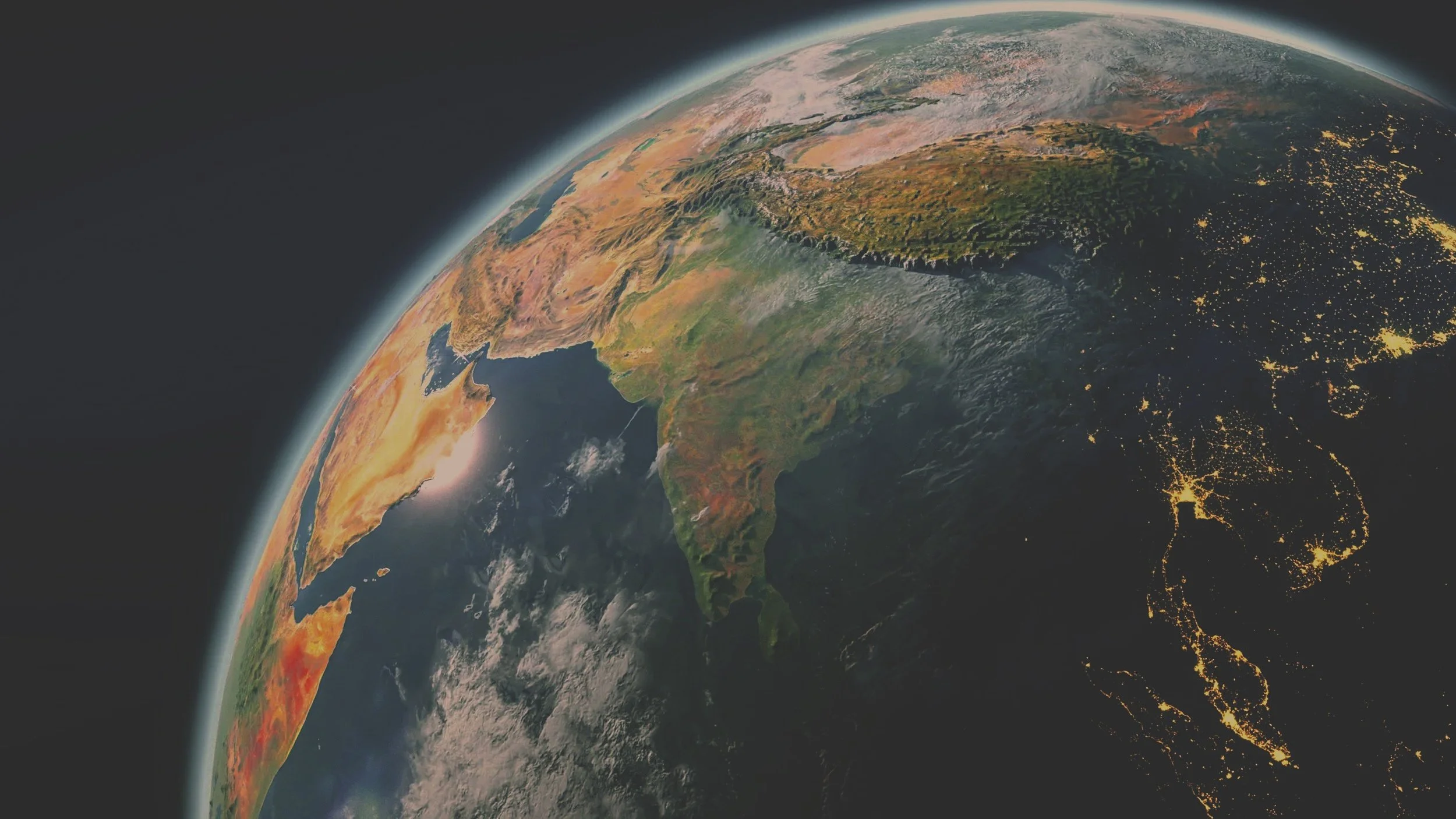 Earth viewed from space showing Asia, the Middle East, and parts of Africa and Europe, with city lights visible at night.