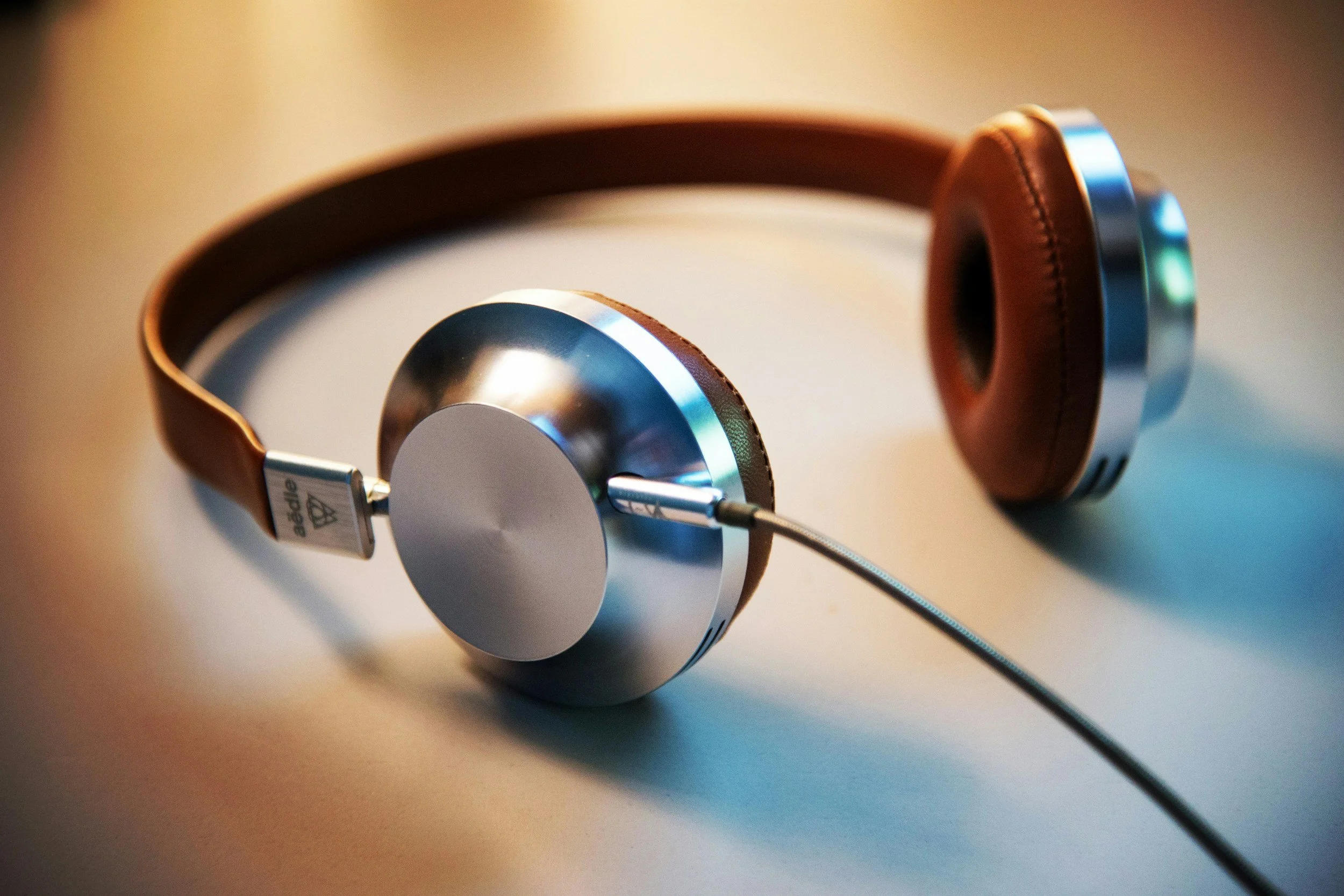 Silbernes Headset mit braunem Leder liegt auf einem Tisch.