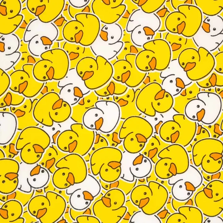 Pattern of yellow rubber duck illustrations with black eyes and orange beaks, and white ducks with orange beaks, densely packed together.