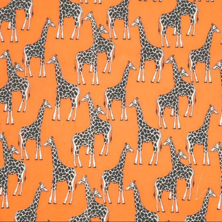Pattern of multiple cartoon-style giraffes with black spots on orange background.