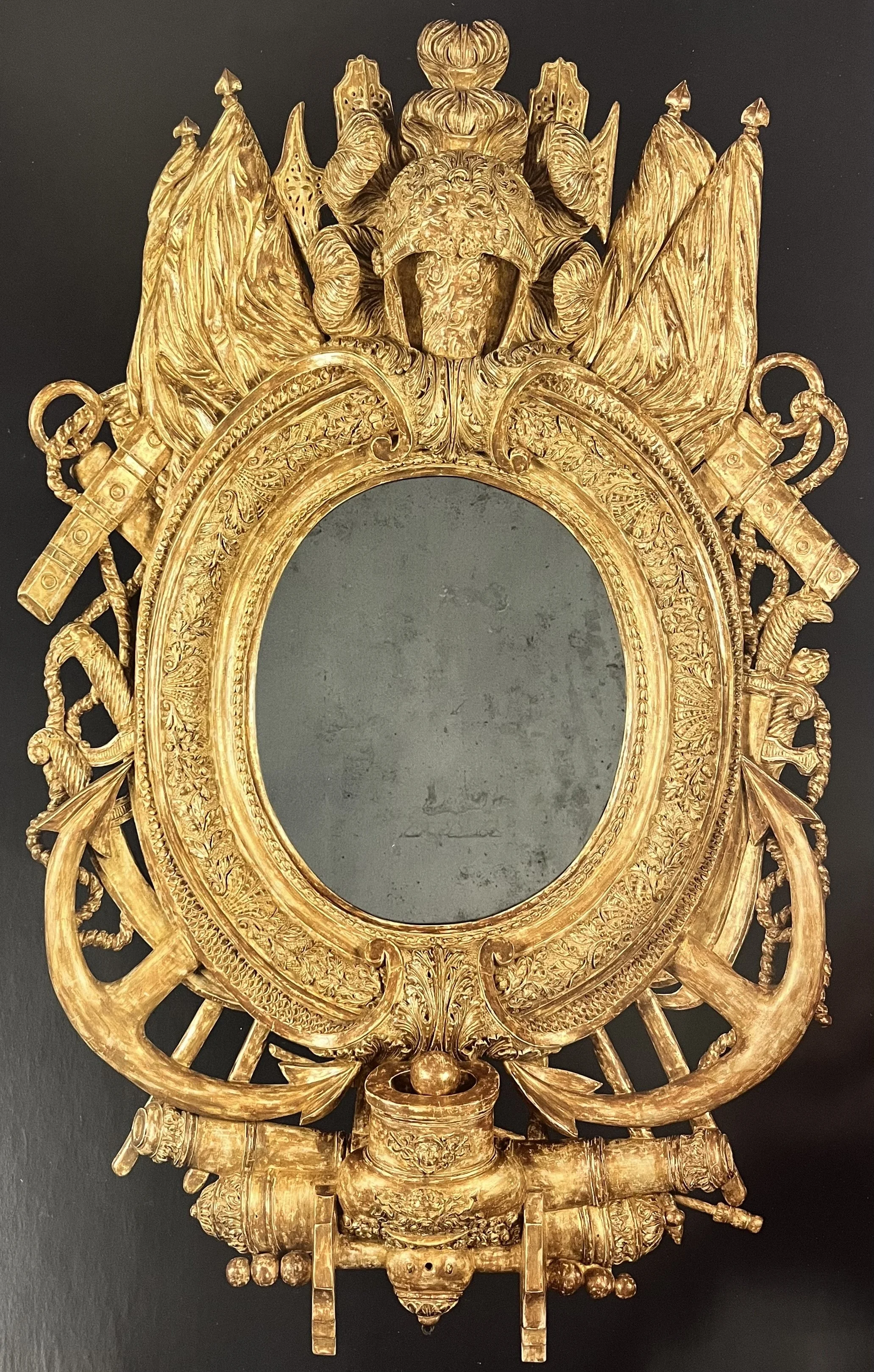 Ornate golden mirror frame with intricate detailing, featuring a lion's head, ribbons, and floral motifs, designed in a Baroque style.