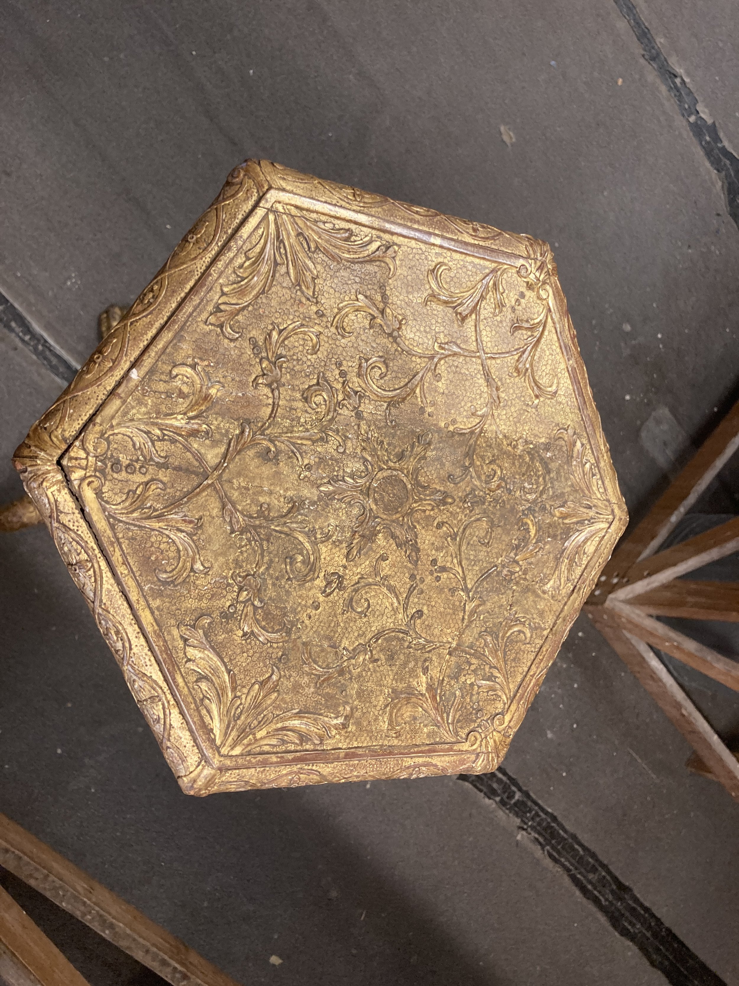Close-up of an ornate, gold-colored box with detailed floral and scrollwork decorations on the surface.