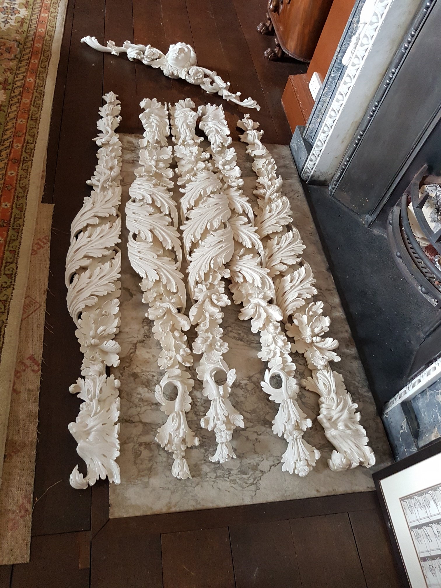 Decorative white plaster moldings with intricate floral and leaf patterns.