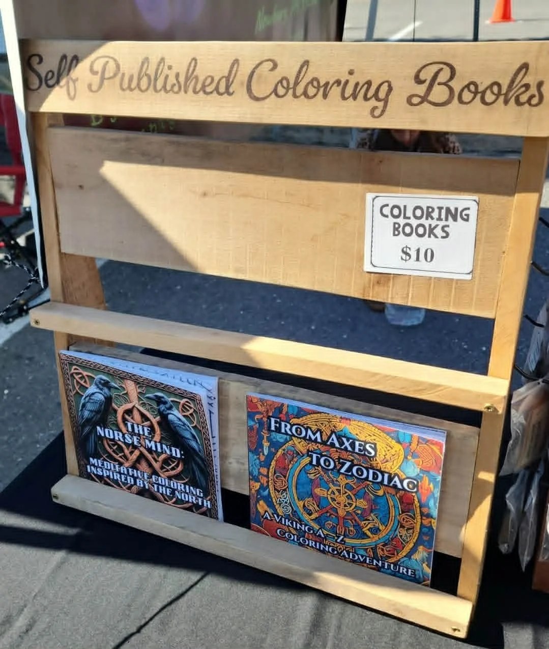 From Axes to Zodiac and The Norse Mind coloring books displayed at the Heathen Farms market table