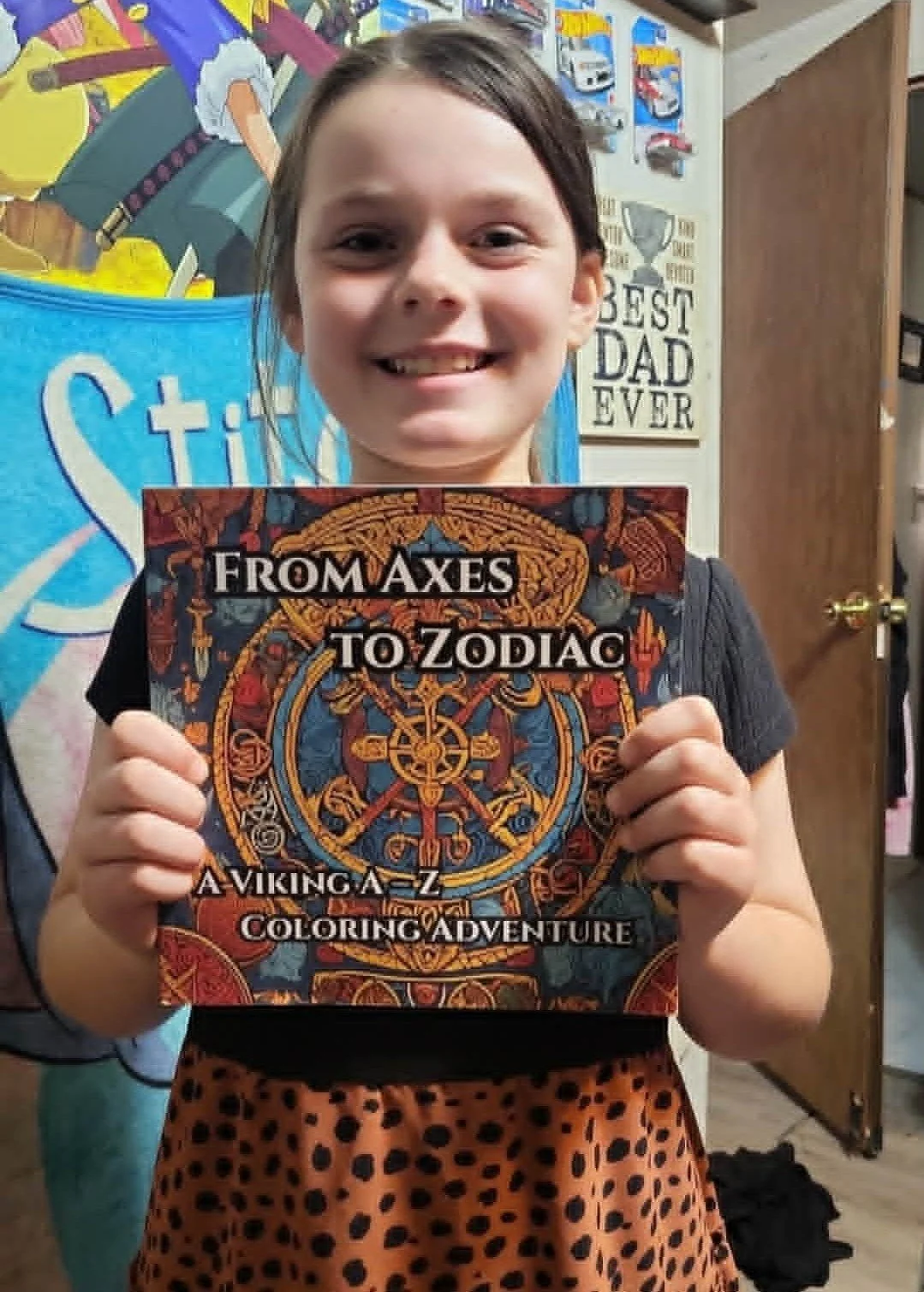 Heathen Farms child smiling and holding a self-published coloring book from Heathen Farms