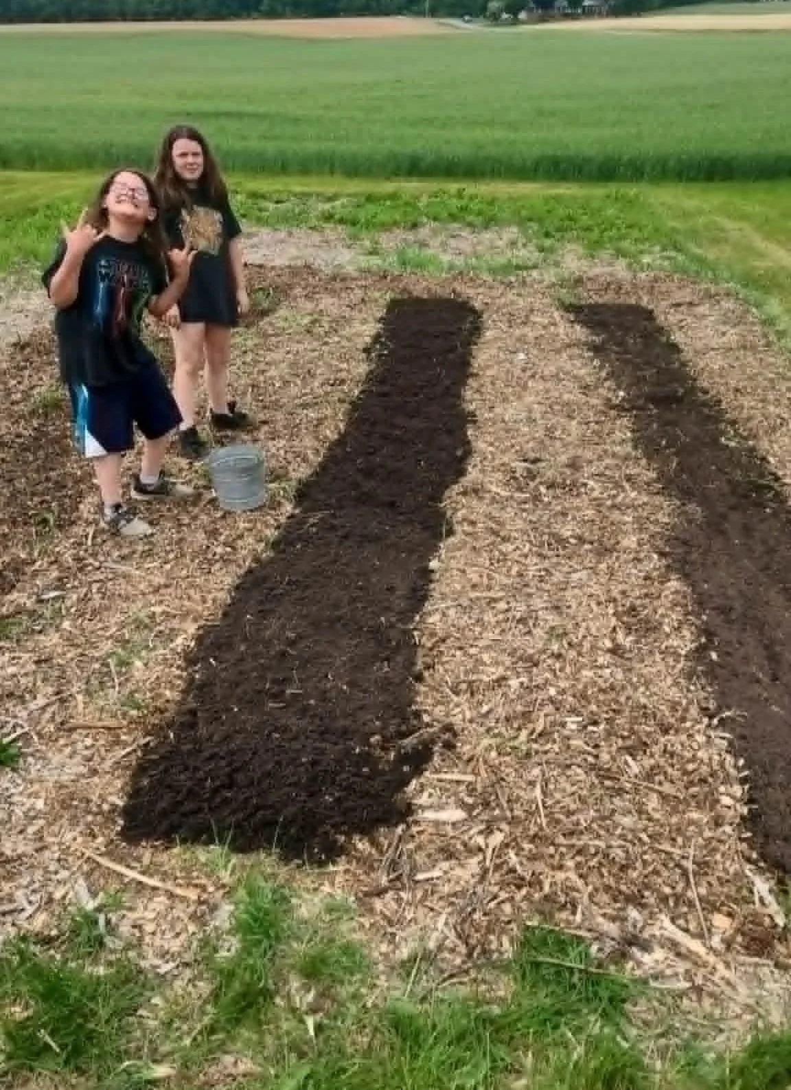 Children beside newly prepared garden beds at Heathen Farms