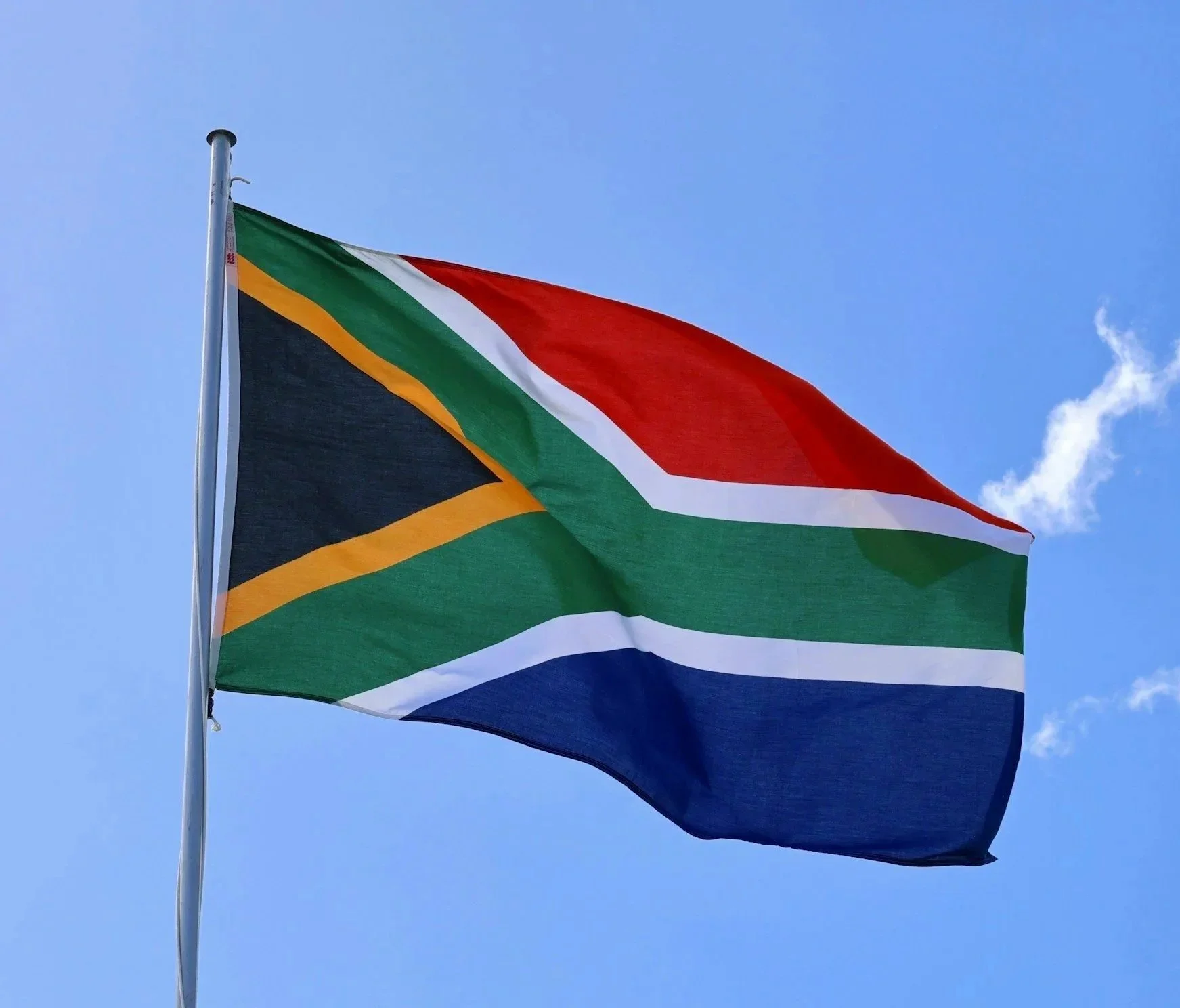 South African flag flying against a clear blue sky.