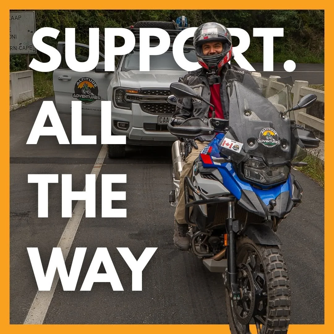 Person on a motorcycle parked on a road, with a support vehicle behind them, and large white text that says "Support. All the Way" overlayed on the image.