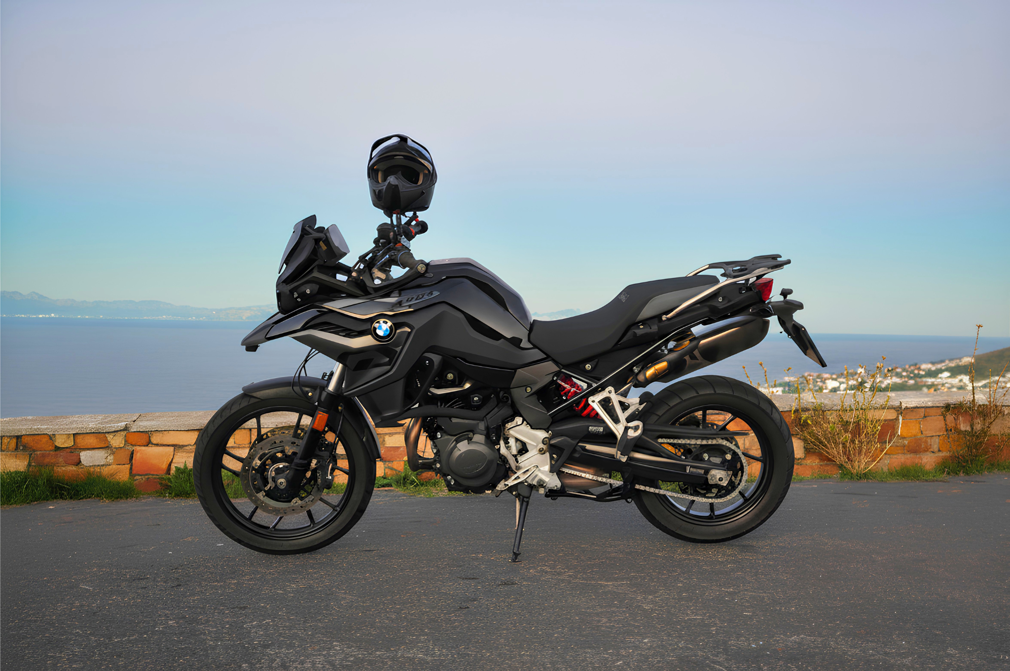Black BMW F800GS adventure motorcycle rental with sunset over simon's town in Cape Town, South Africa