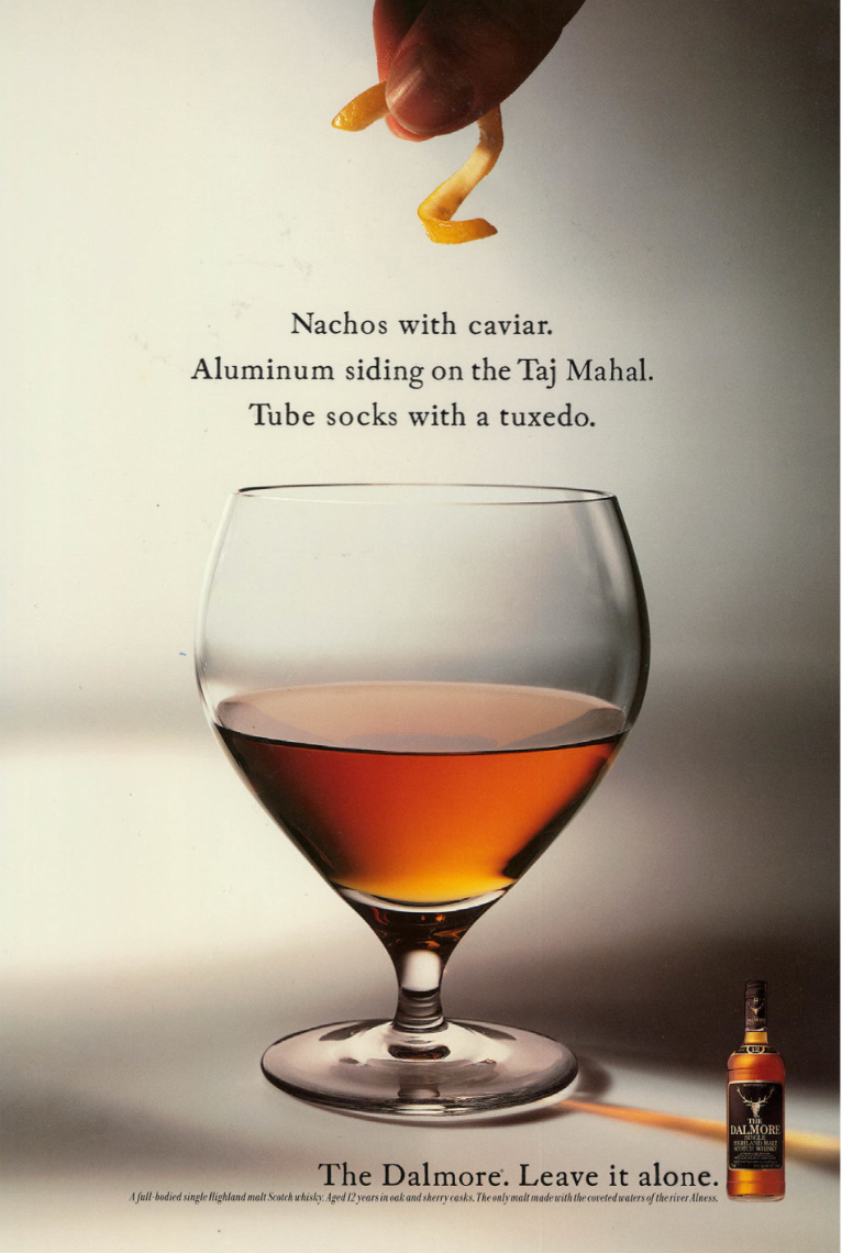 A hand holding a French fry above a glass of whiskey. Text describes a fancy snack combo including nachos with caviar, aluminum siding on the Taj Mahal, and tube socks with a tuxedo. There is a bottle of Dalmore whiskey in the corner with the slogan "Leave it alone."