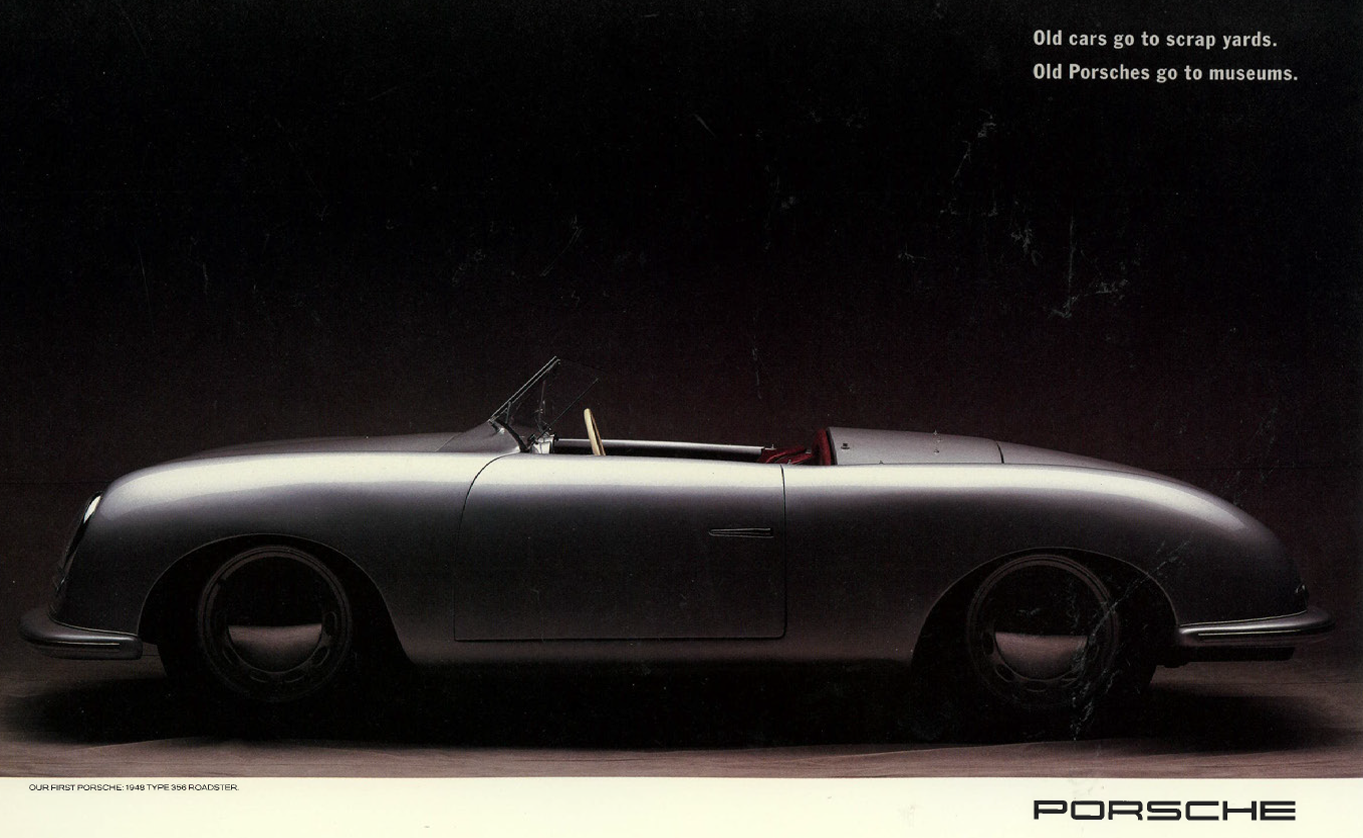 Side view of a vintage silver Porsche roadster with a black background and white text in the upper right corner.