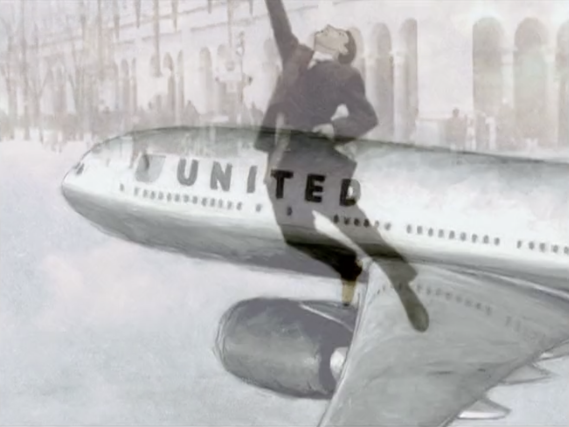 Reflection of a person wearing glasses and a dark jacket, holding a sign that says "United," on a shiny, curved surface with a white textured background.