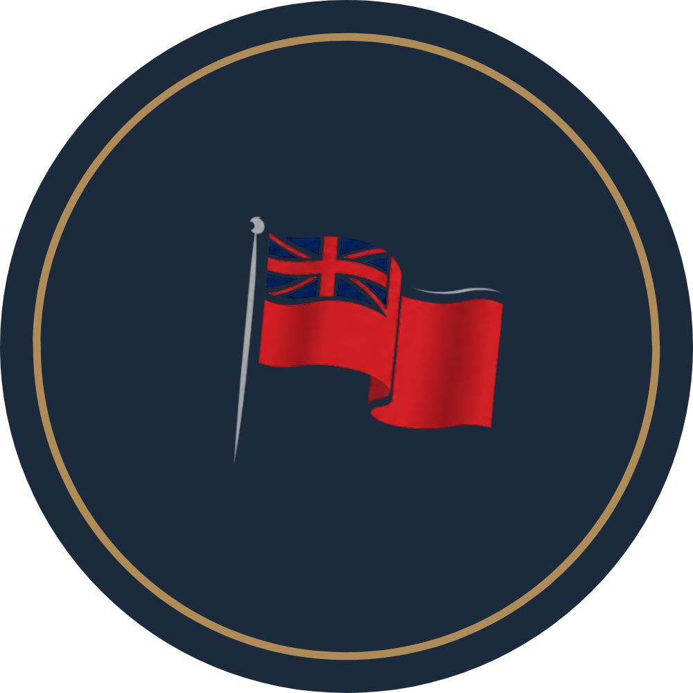 A flag with a Union Jack at the top left corner and a solid red field, waving on a pole against a dark background with a gold circle border.