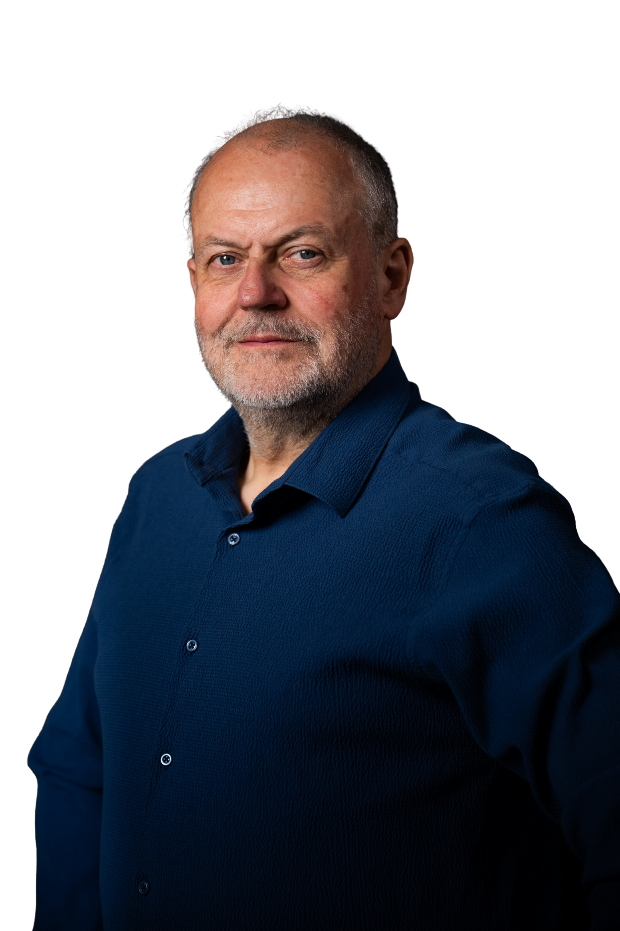 Portrait of a middle-aged man with a beard and blue eyes, wearing a navy blue button-up shirt, against a black background.