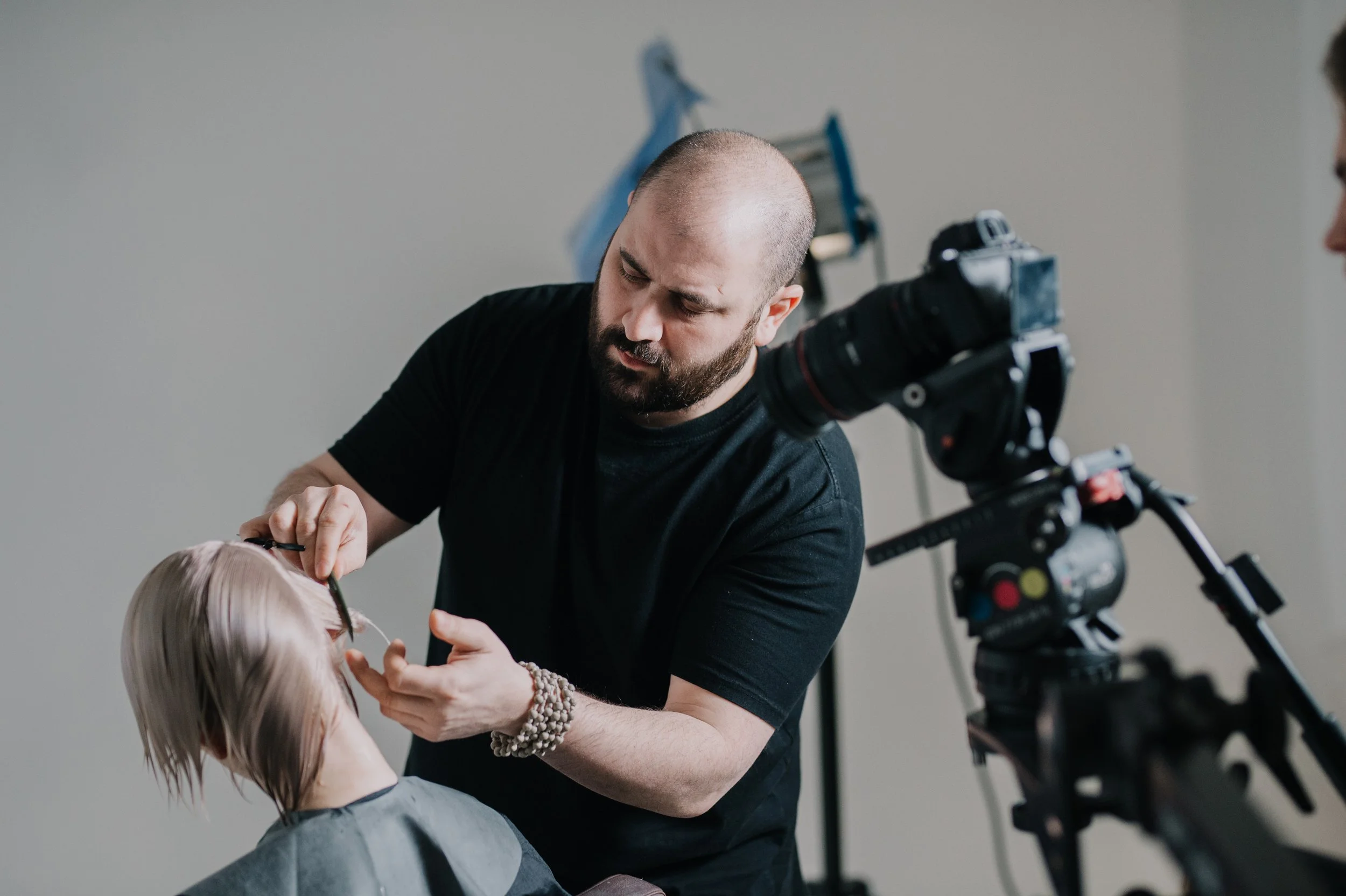 Ein Friseur macht einer älteren Frau einen Haarschnitt in einem Friseursalon.
