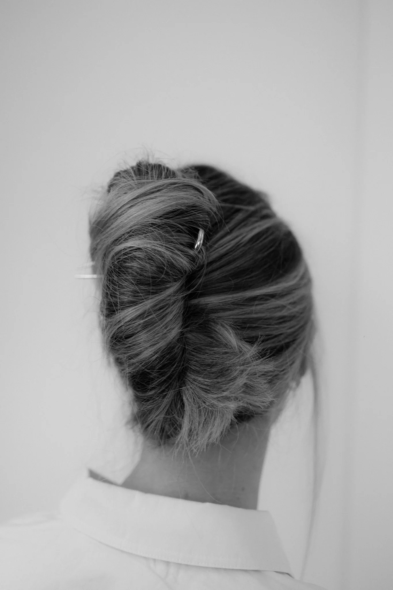 Schwarz-weiß-Foto eines verzierten Haarknotens auf einem Papier mit einem Geflecht aus Haaren.