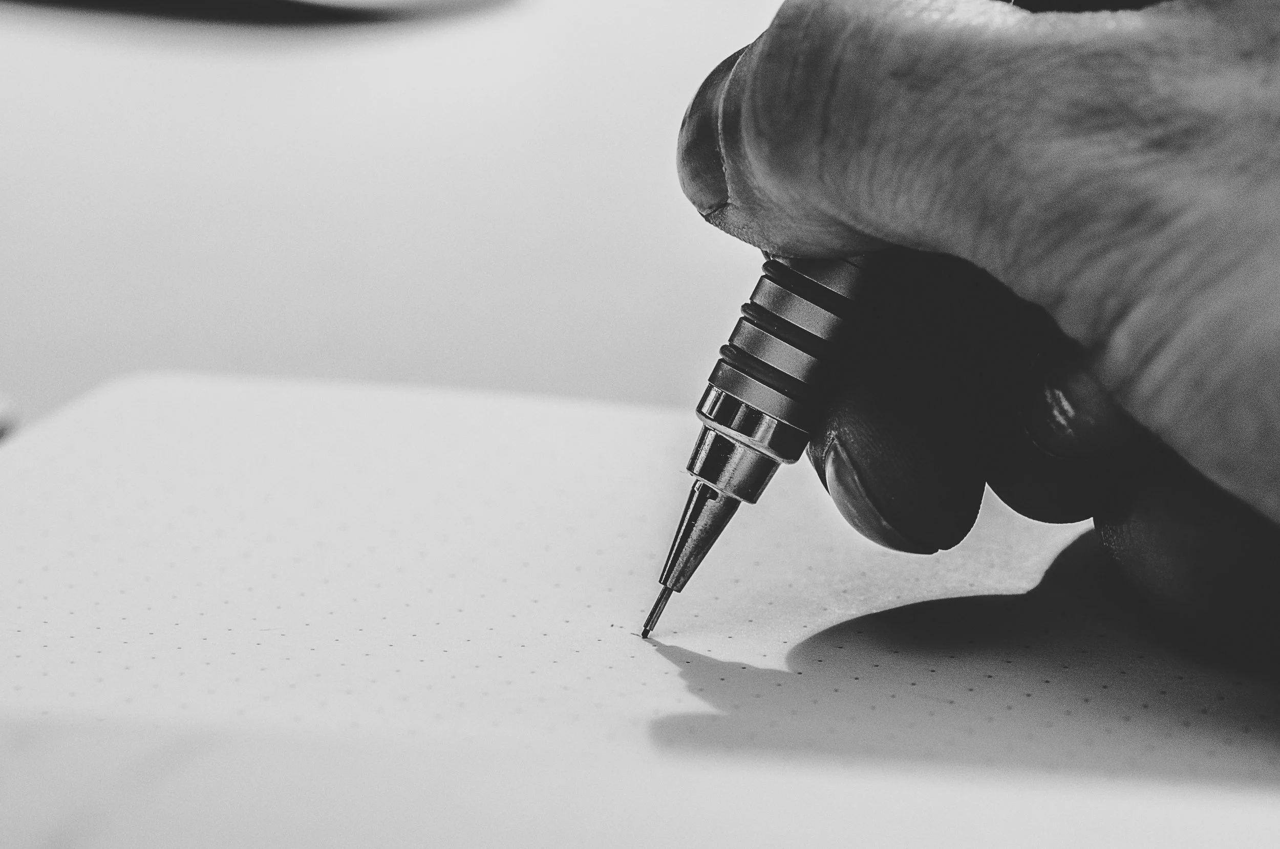 A landscape designer sketching a garden design detail with a technical pen.