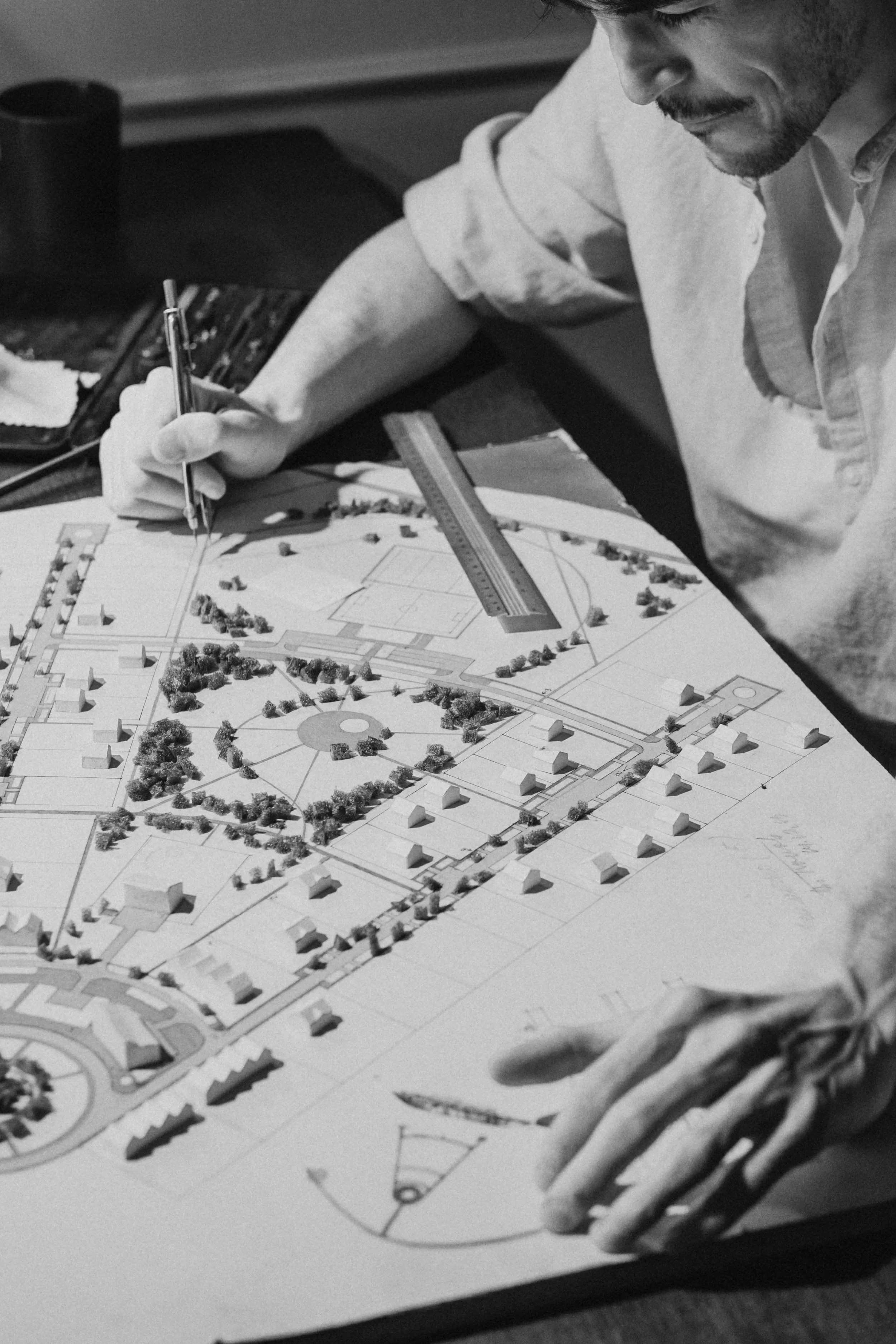 A landscape design scale model showing paths, planting areas and surrounding buildings.