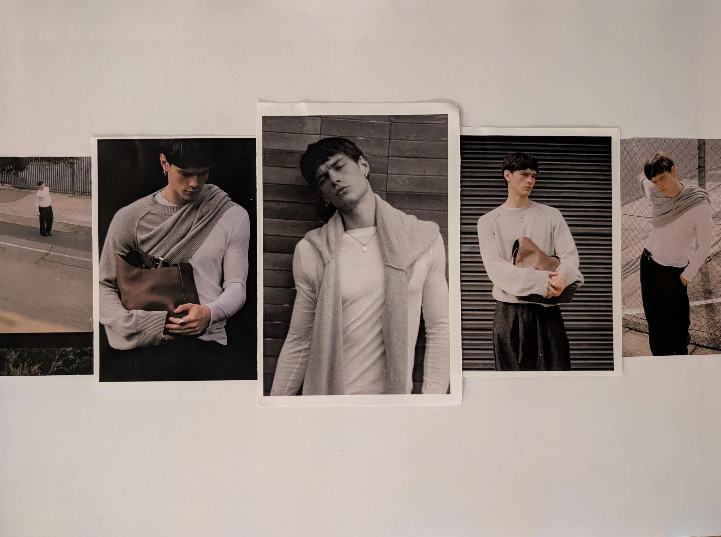 Set of printed photographs of a young man with dark hair in various poses, including looking down, tilting head, and crossing arms, displayed against a plain surface.