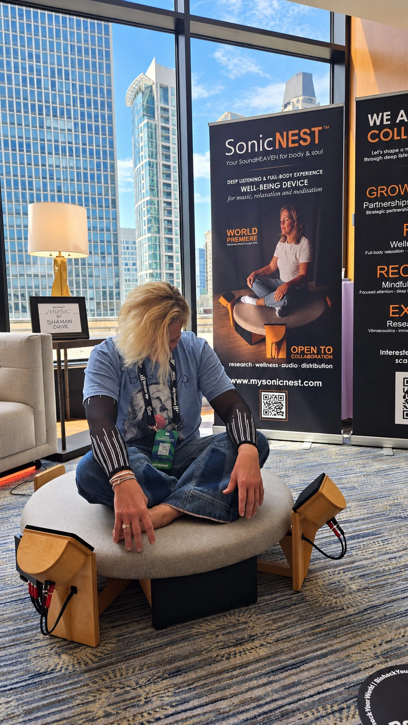 SonicNEST™ listening session in Chicago with city skyline view, showing an immersive sound-and-vibration experience for relaxation and mindful presence.