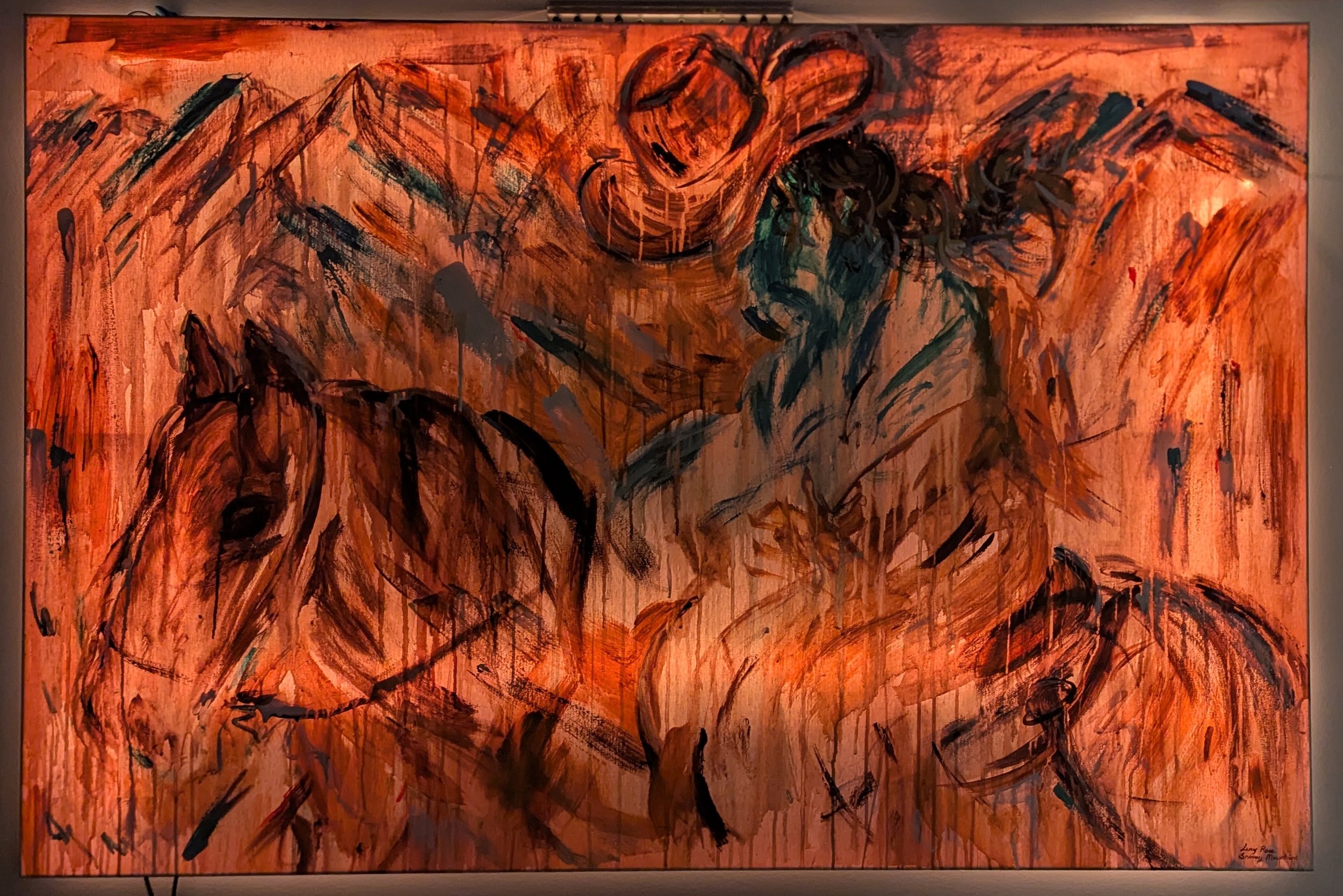 An abstract painting with a warm orange background featuring black and dark teal bold, expressive brushstrokes depicting muscular male figures wearing cowboy hats, with some figures sitting and others standing, all rendered in a loose, energetic style.