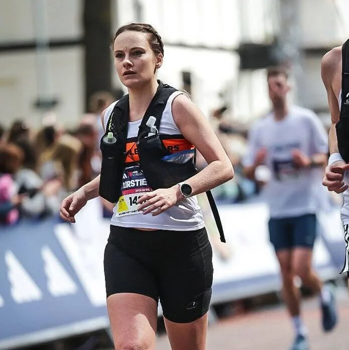 Female marathon runner in race bib and athletic gear training outside