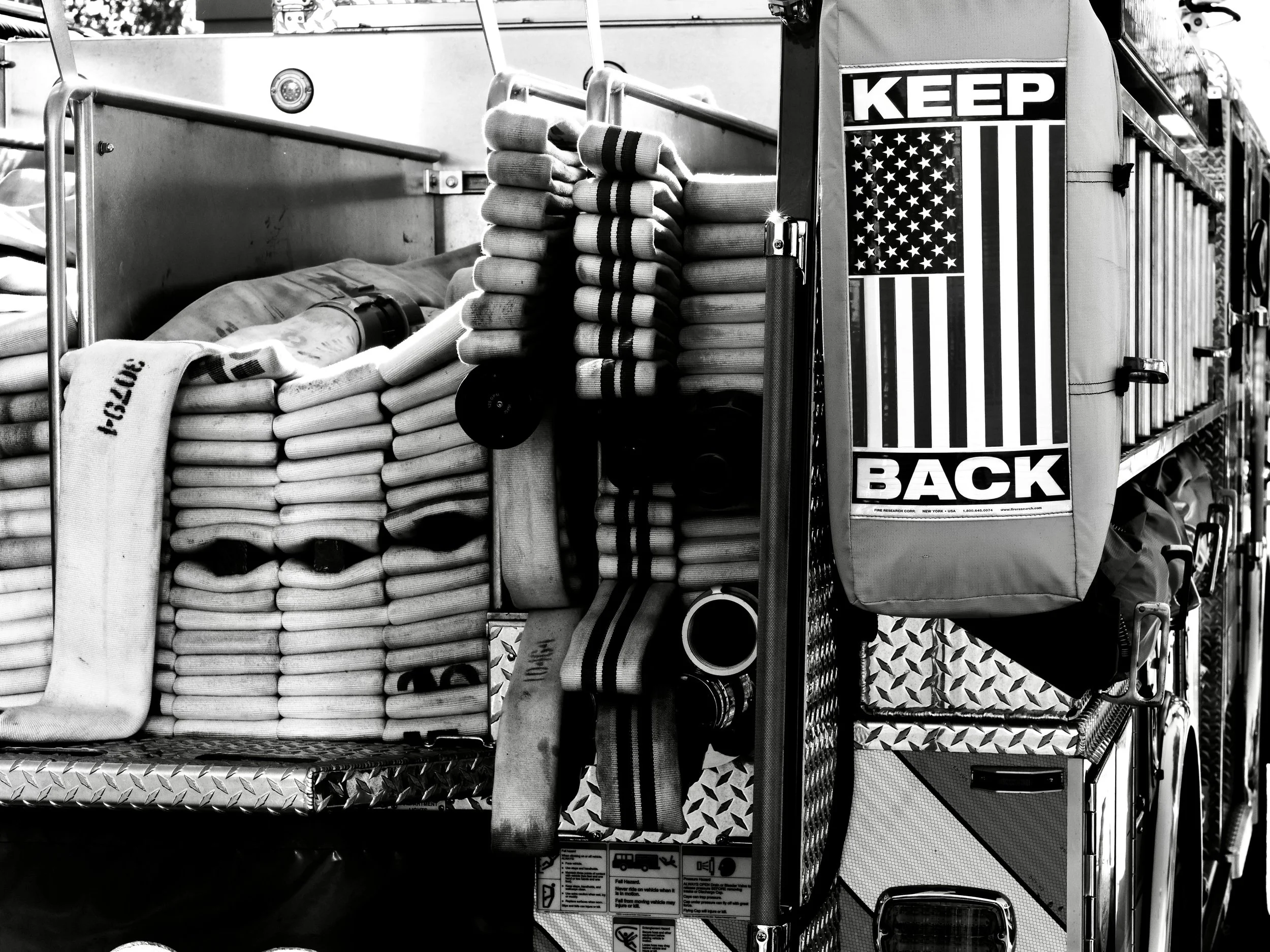 Fire Hose in the back of a fire truck. Safety sign. Retired chief officers with experience in fire service management.