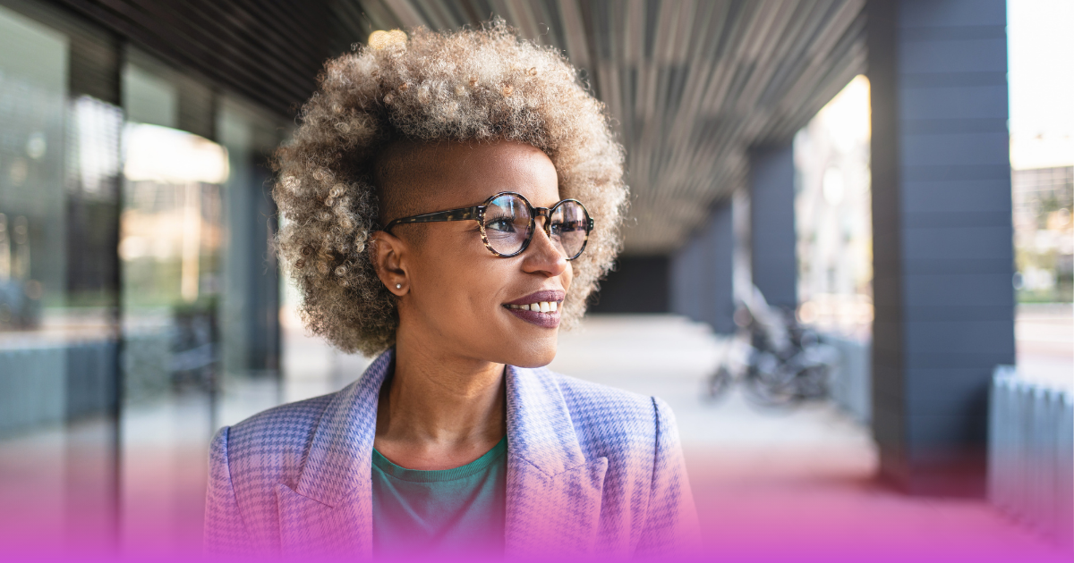 Professional woman smiling outdoors while reflecting on leadership growth and career development