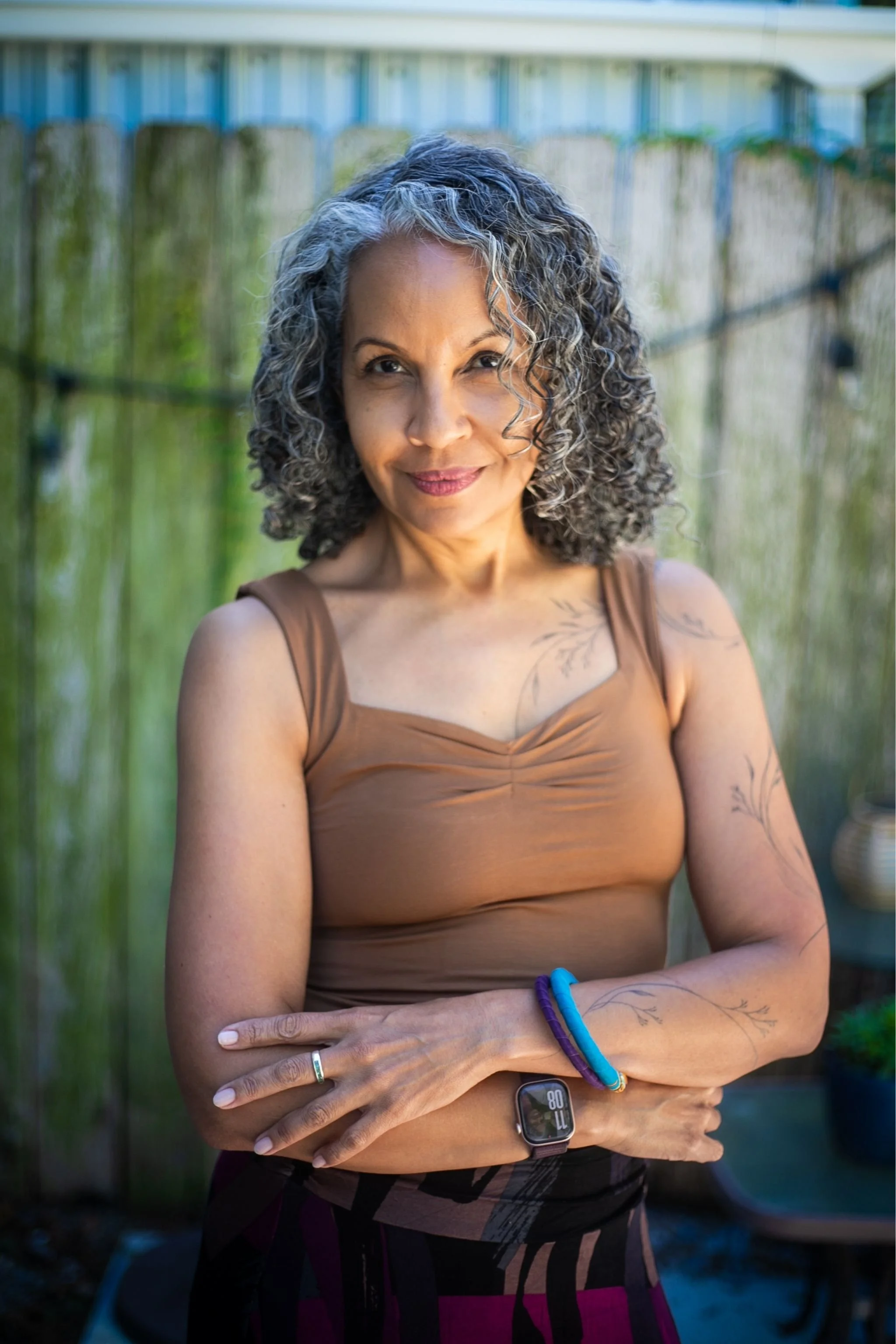 Dr. Michelle Ramos, leadership coach and consultant, seated outdoors and smiling at the camera