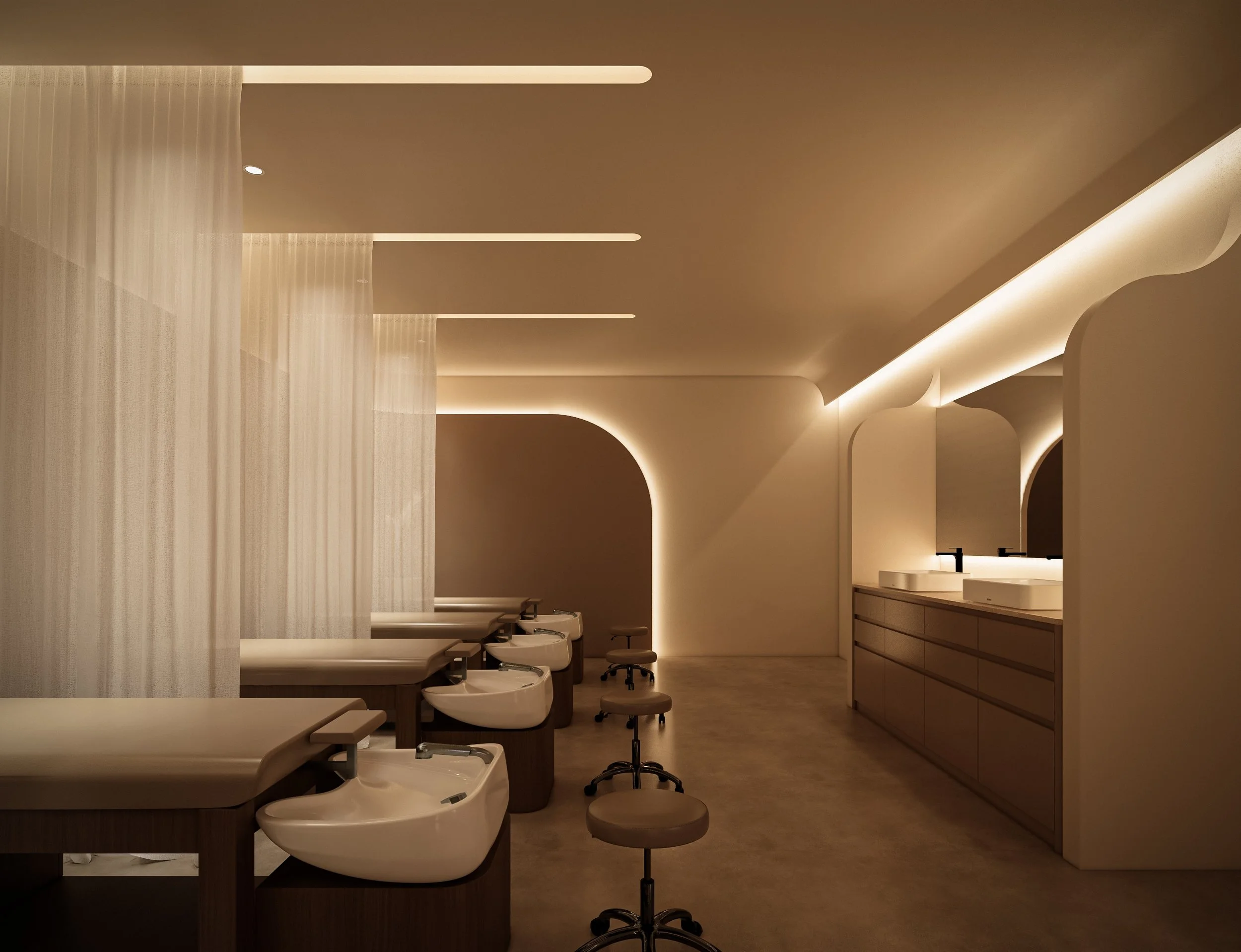 A modern, minimalist interior with a row of white sinks and stools under a curved, warm-colored ceiling featuring integrated lighting. There are wooden cabinets on the right side and sheer white curtains on the left.