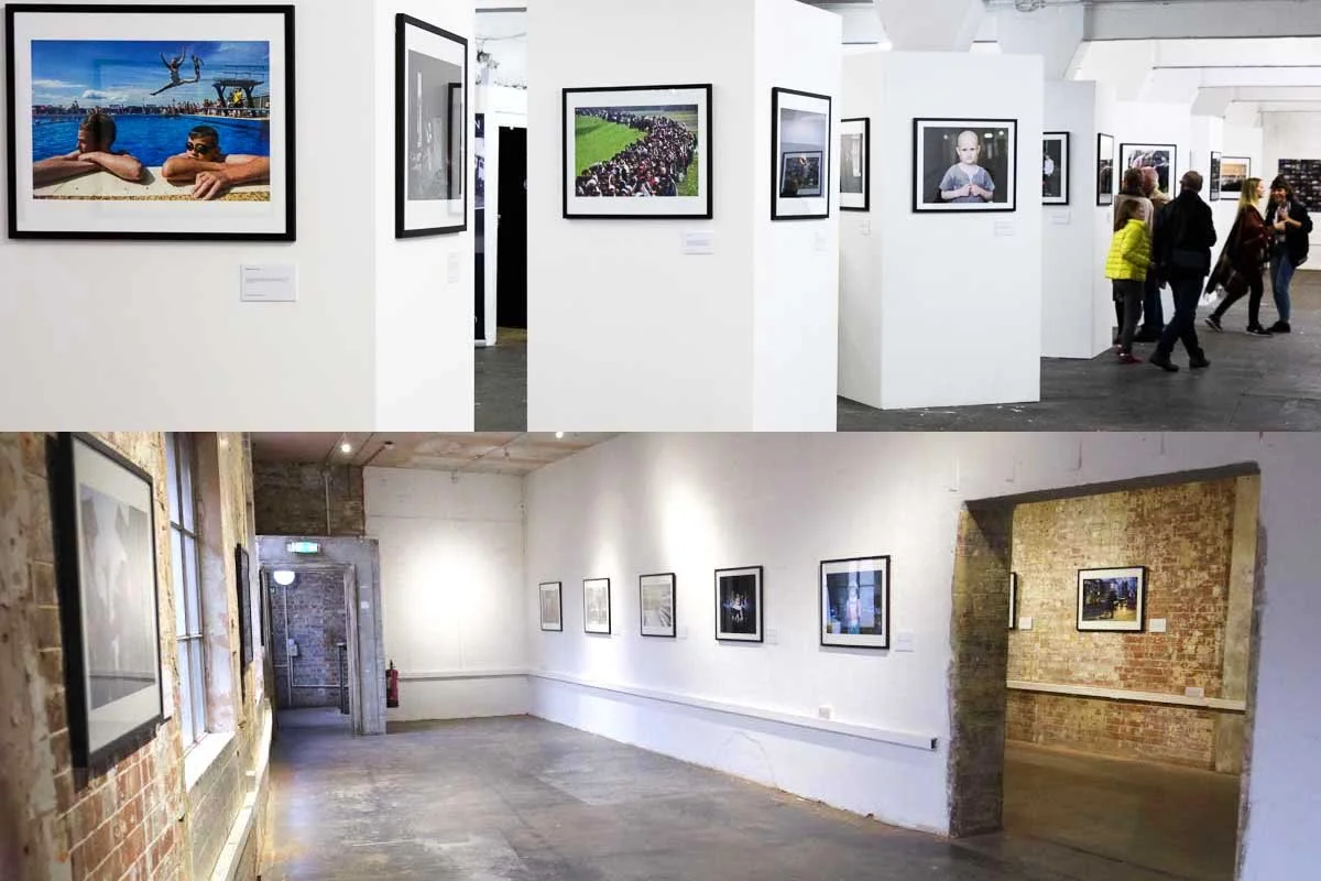Two photos of art galleries with framed photographs on white walls. The top photo shows a modern gallery with visitors, white walls, and black frames, while the bottom photo displays an industrial-style gallery with brick walls, wooden floors, and a 