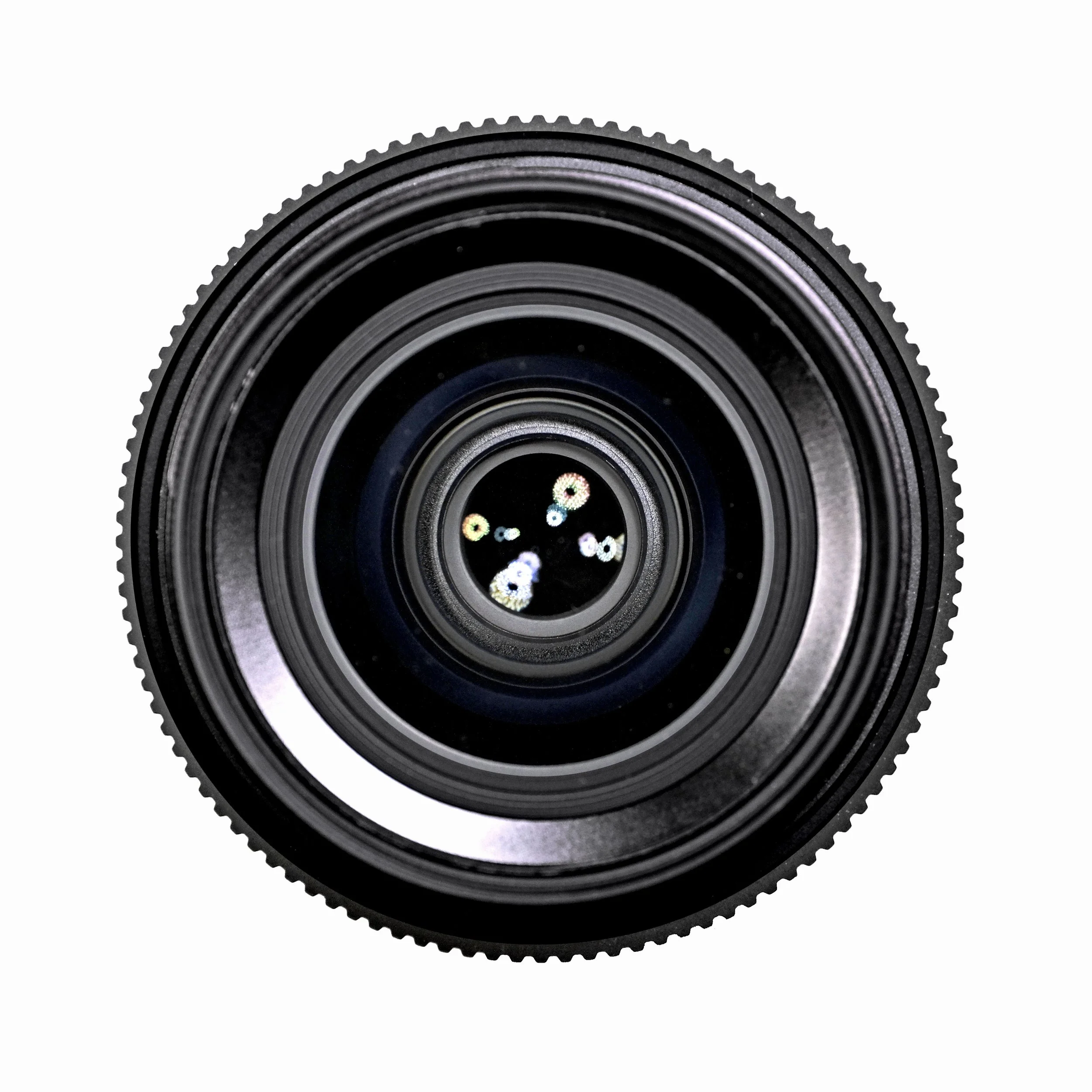Close-up of a camera lens with multiple concentric rings and a reflection of colorful lights at the center.