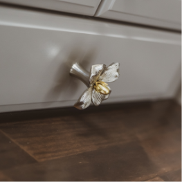 A kitchen drawer with a decorative flower knob mounted on the front.