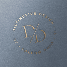 Logo with a circle of text reading 'Distinctive Design 20 Toledo Ohio' surrounding a stylized 'D/' monogram.