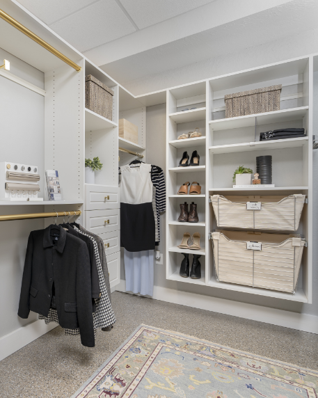 Walk-in closet with organized shelves for shoes, clothing, and accessories, including baskets and boxes.
