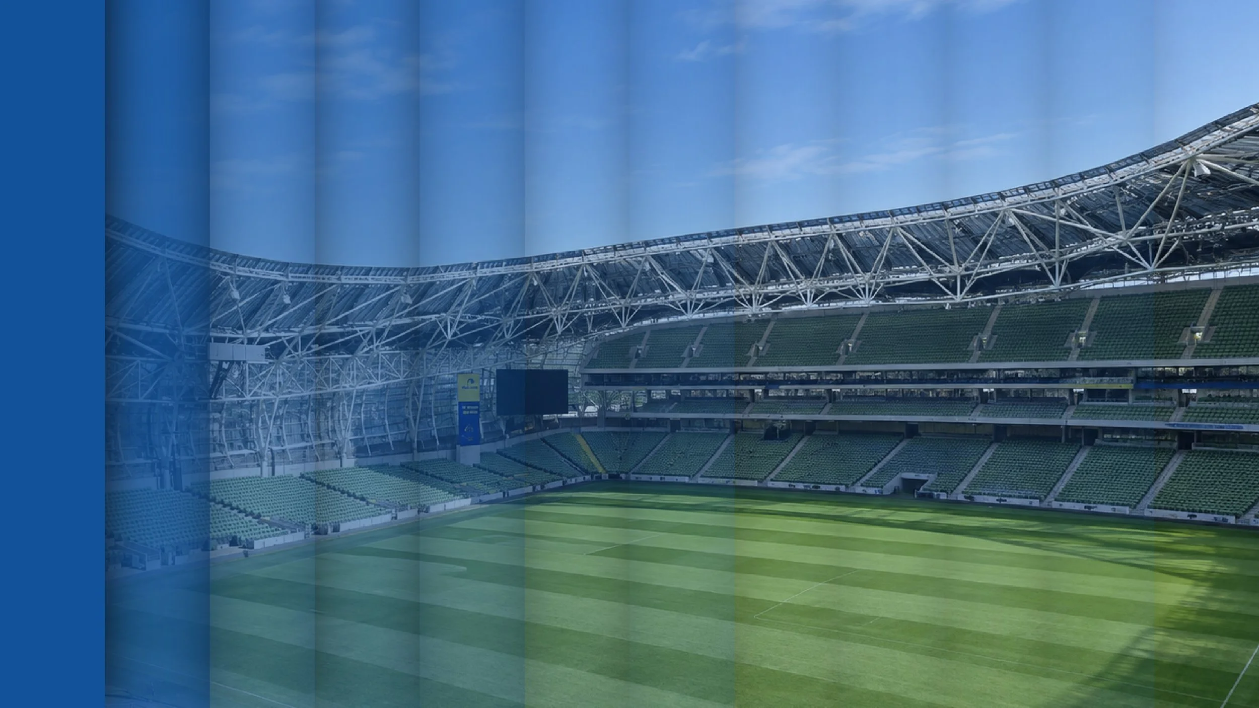 Empty modern outdoor stadium with green field, seating sections, and a partly covered roof. The image has a blue panelled effect that becomes more translucent the further right it goes