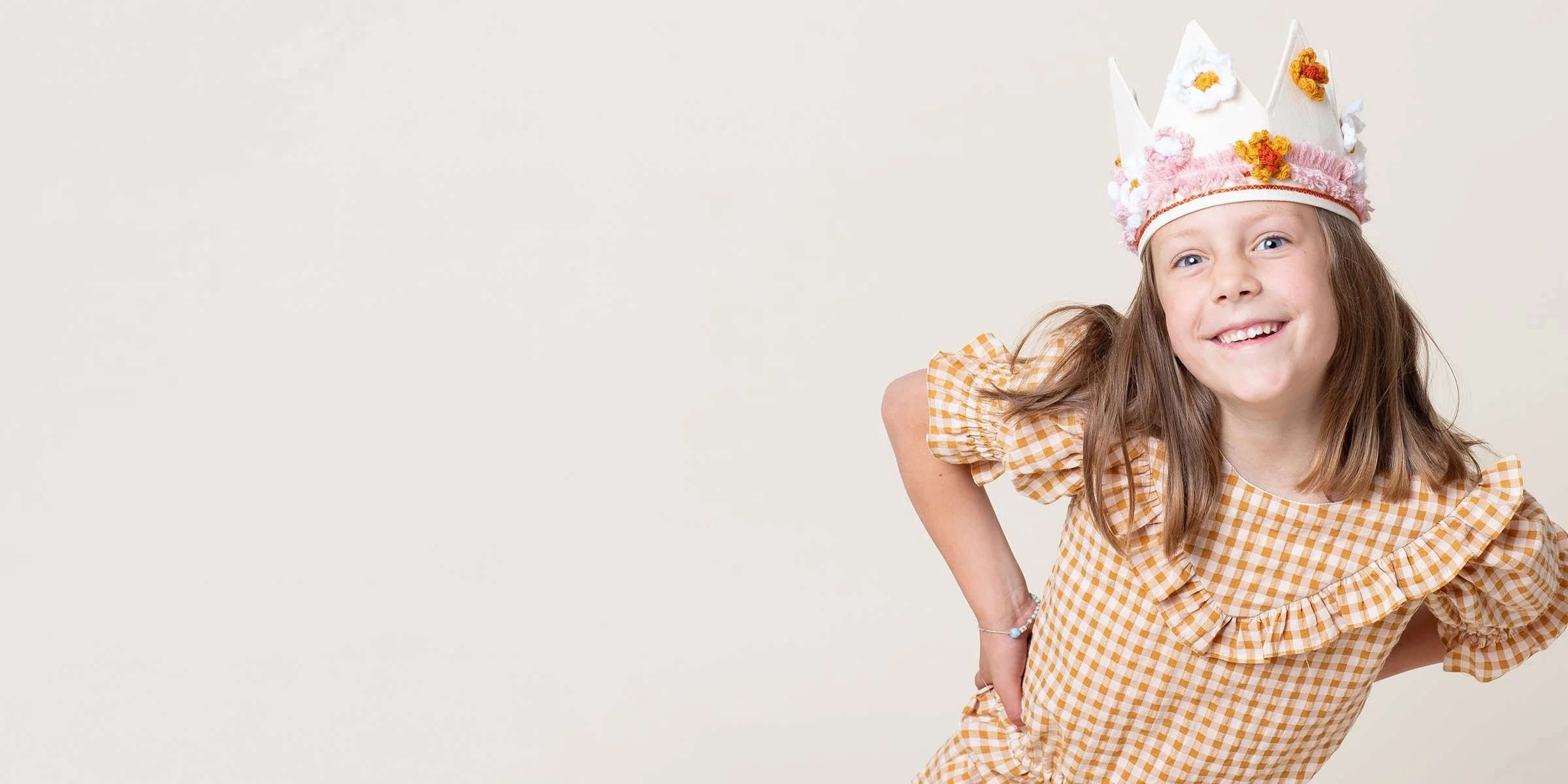 A young girl wearing a handcrafted flower crown during a milestone birthday photoshoot at the Poppie Portraits studio in Seattle.