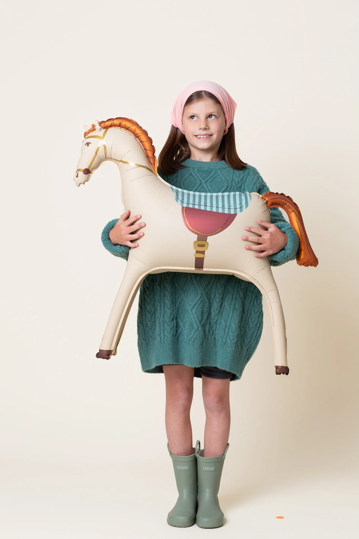 A young girl holding a boutique horse balloon for a milestone birthday photos session at Poppie Portraits in Seattle.  