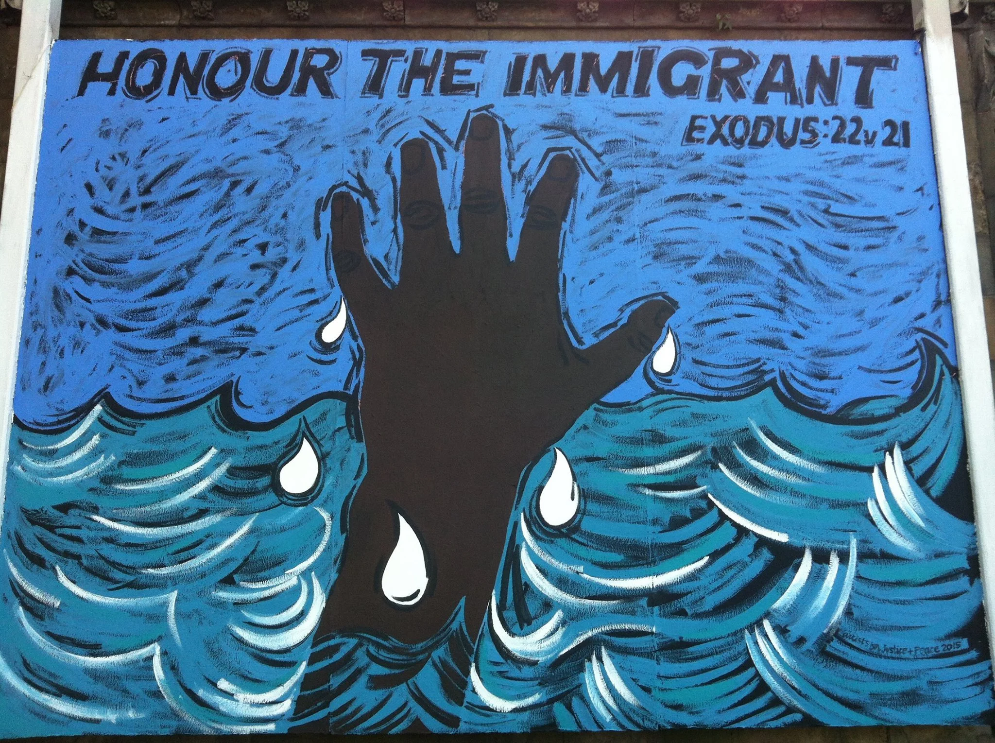 A mural with a black hand showing three fingers and a thumb, surrounded by swirling blue and white waves. The text above the hand reads 'HONOUR THE IMMIGRANT' and includes a Bible verse reference 'EXODUS 22:21'.