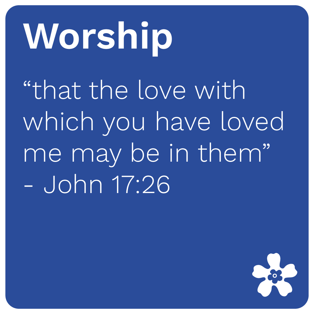 A blue square with white text featuring a Bible verse from John 17:26 about worship and love, decorated with a white flower in the bottom right corner.