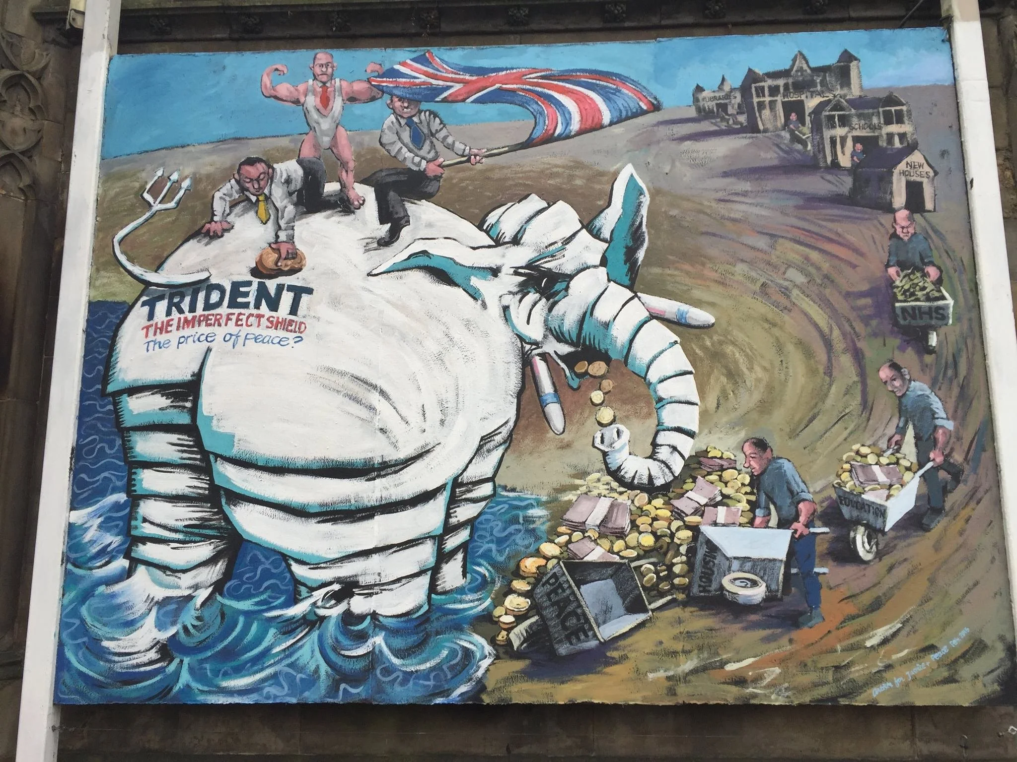 A colorful painted mural depicting a large hand holding a ballot and a ballot box labeled 'ELECTION' with people around it, including a man with a hat, a woman with a bicycle, and buildings in the background. The mural includes a muscular man holding