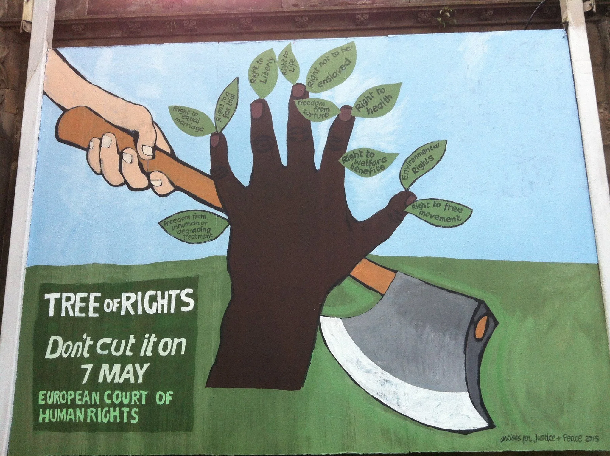 A mural depicting a large tree with human skin tone hands as the trunk and arms, holding a pencil. Green leaves on the tree contain various human rights phrases such as "Right to equal marriage," "Right to freedom from torture," "Right to health," an