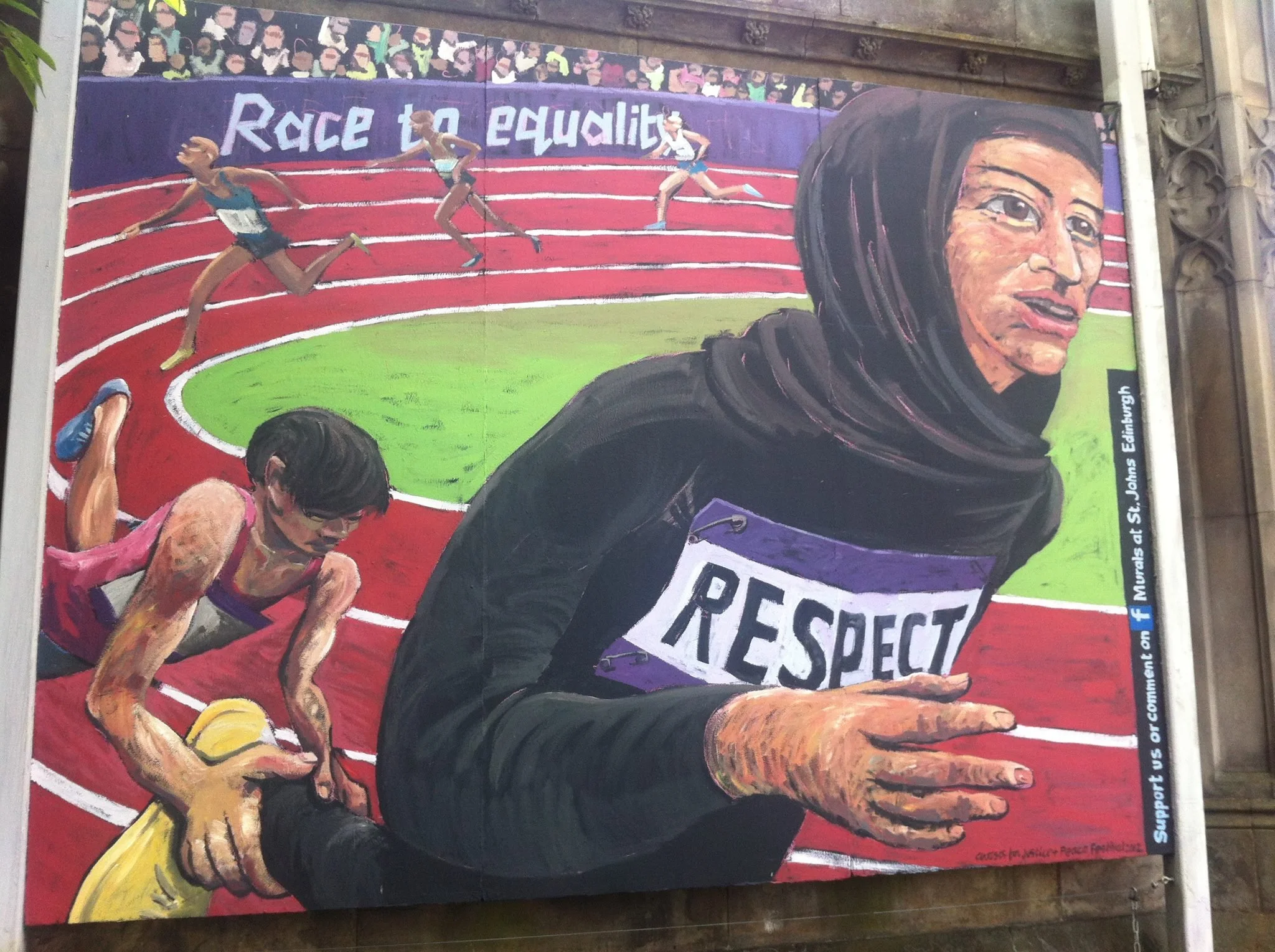 A colorful mural depicting a female athlete crossing the finish line, with the message 'Race to Equality' written above. The mural includes other runners and a crowd in the background, emphasizing themes of equality in sports.