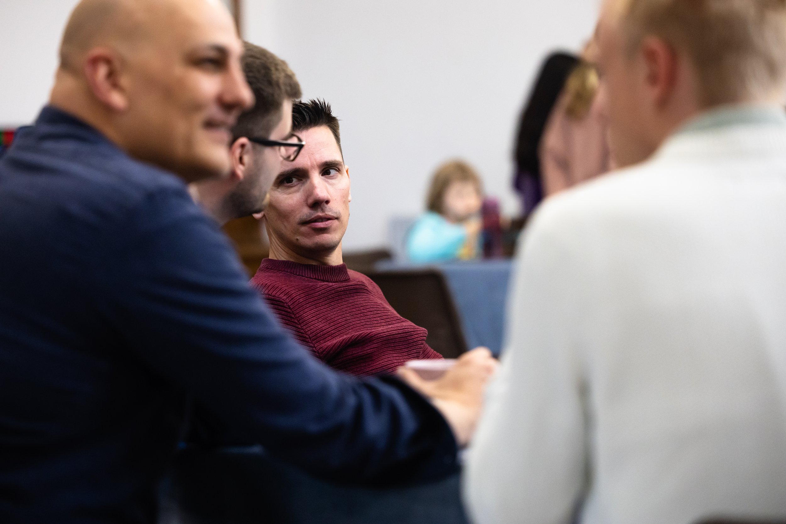 A group of diverse people engaged in a discussion or meeting in a classroom or conference room.