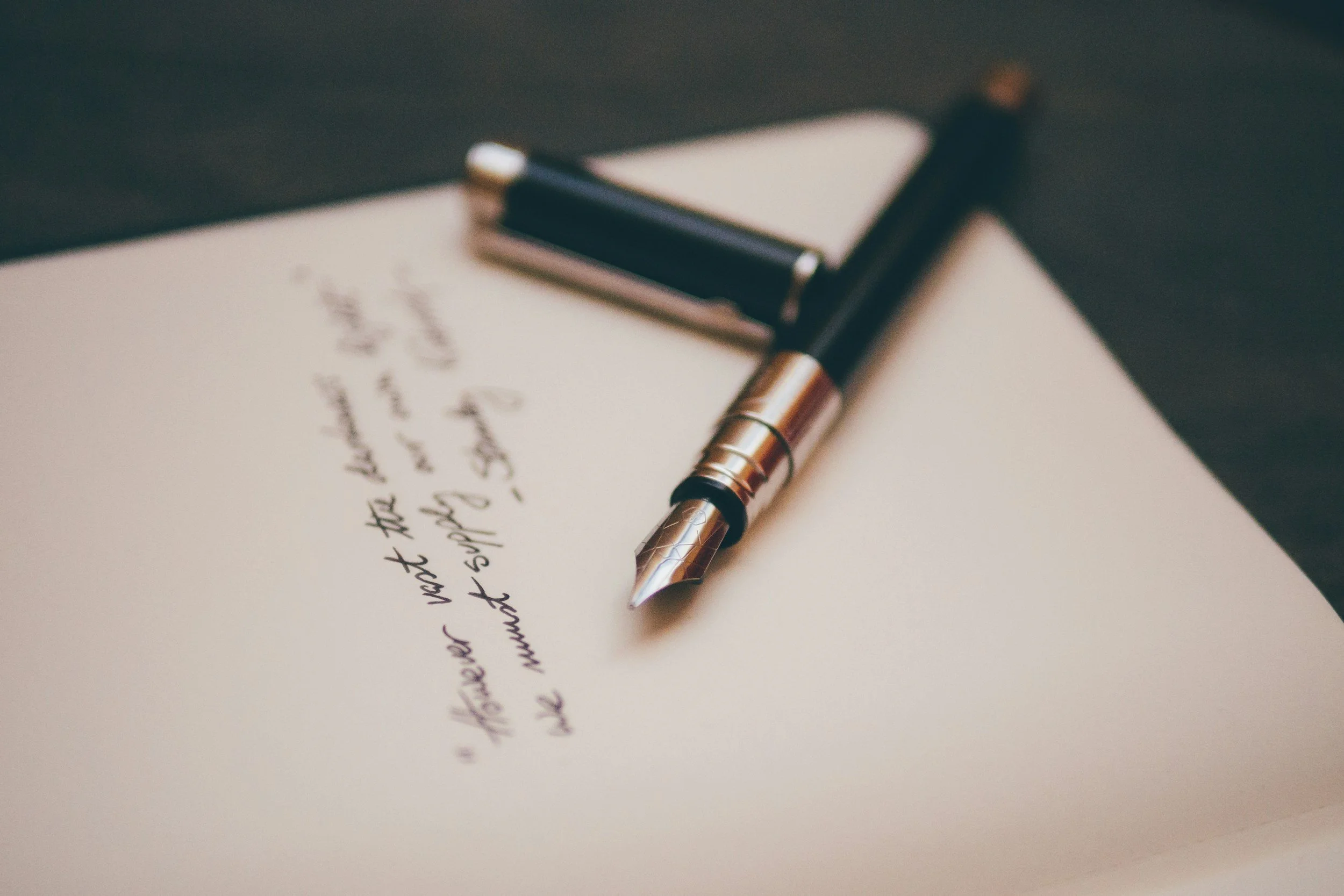 Close-up of a fountain pen resting on a handwritten letter.