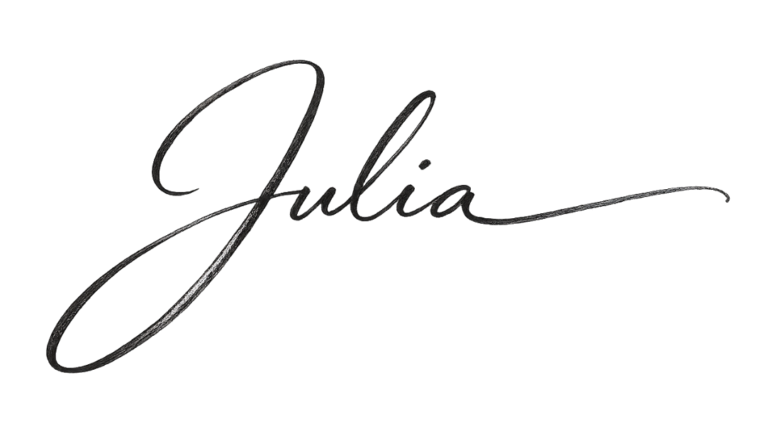 A black, elegant cursive signature of the name 'Julia' on a transparent background.