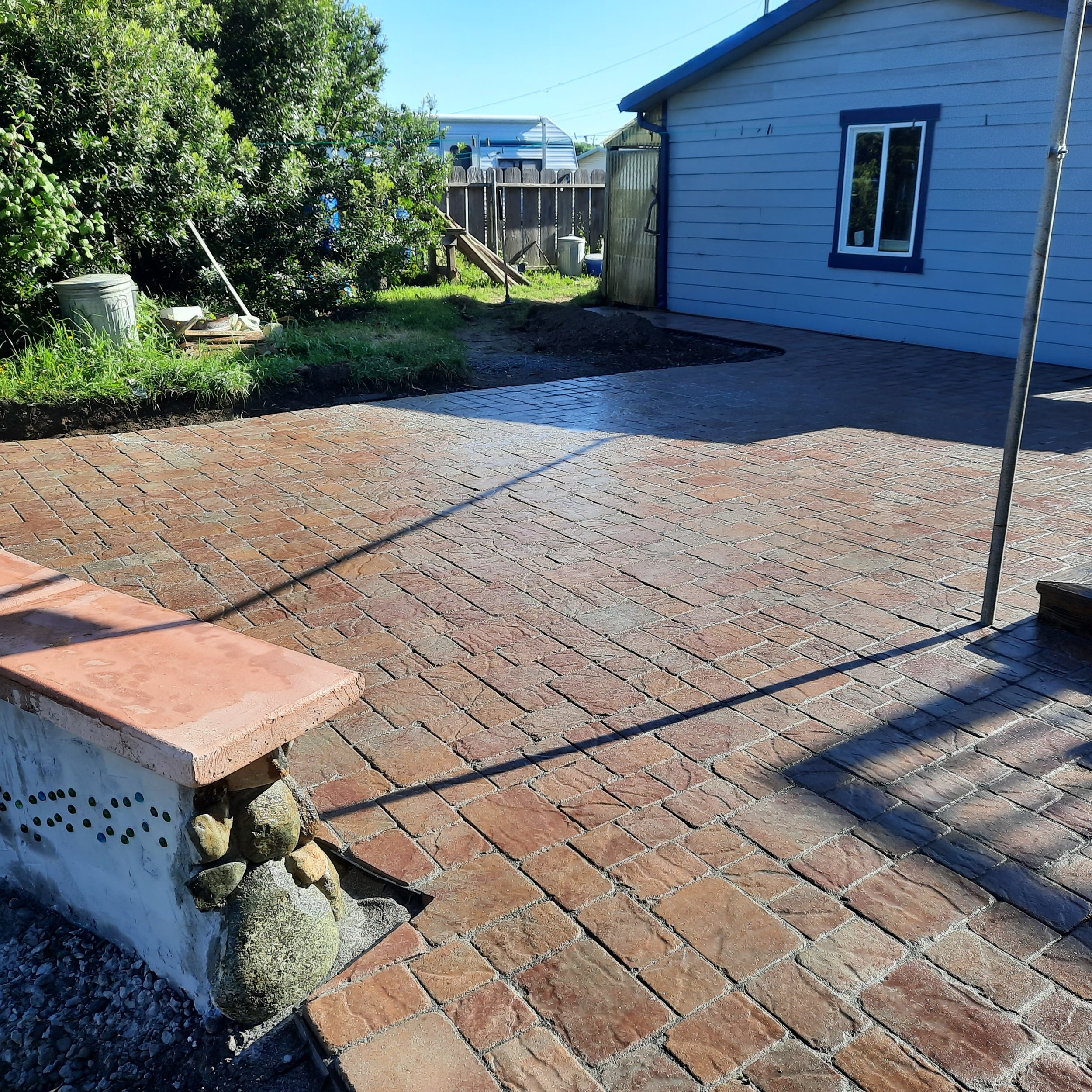 Brick paver patio with garden planting and outdoor living space.