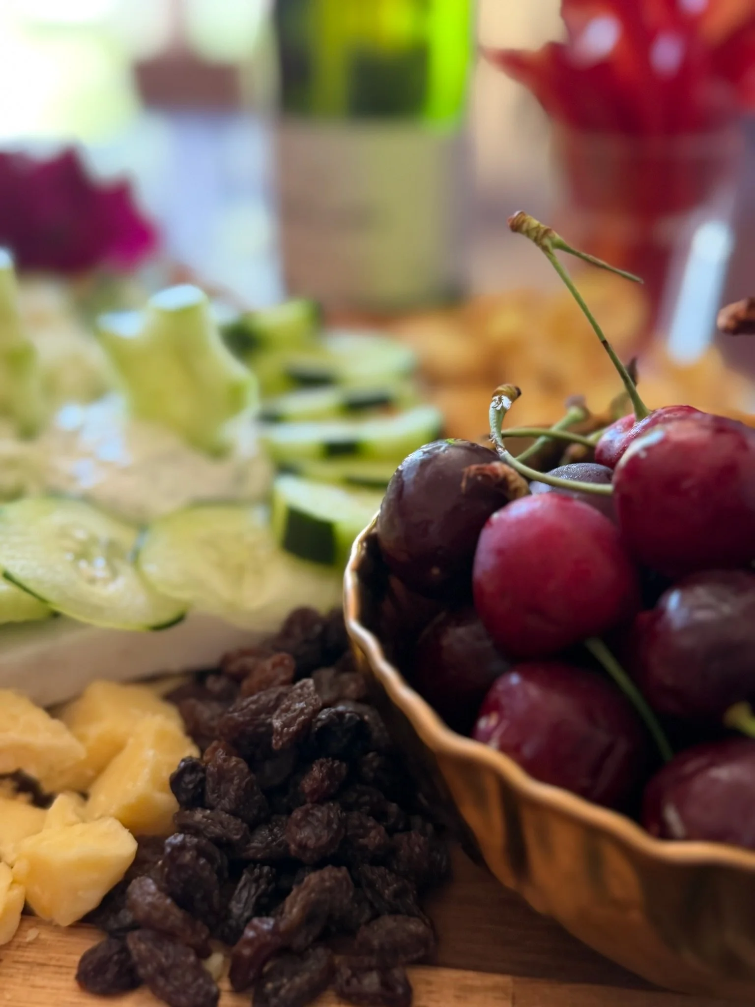 Close-up of assorted grapes in a basket, with sliced pineapple, dark grapes, and other fruits in the background.