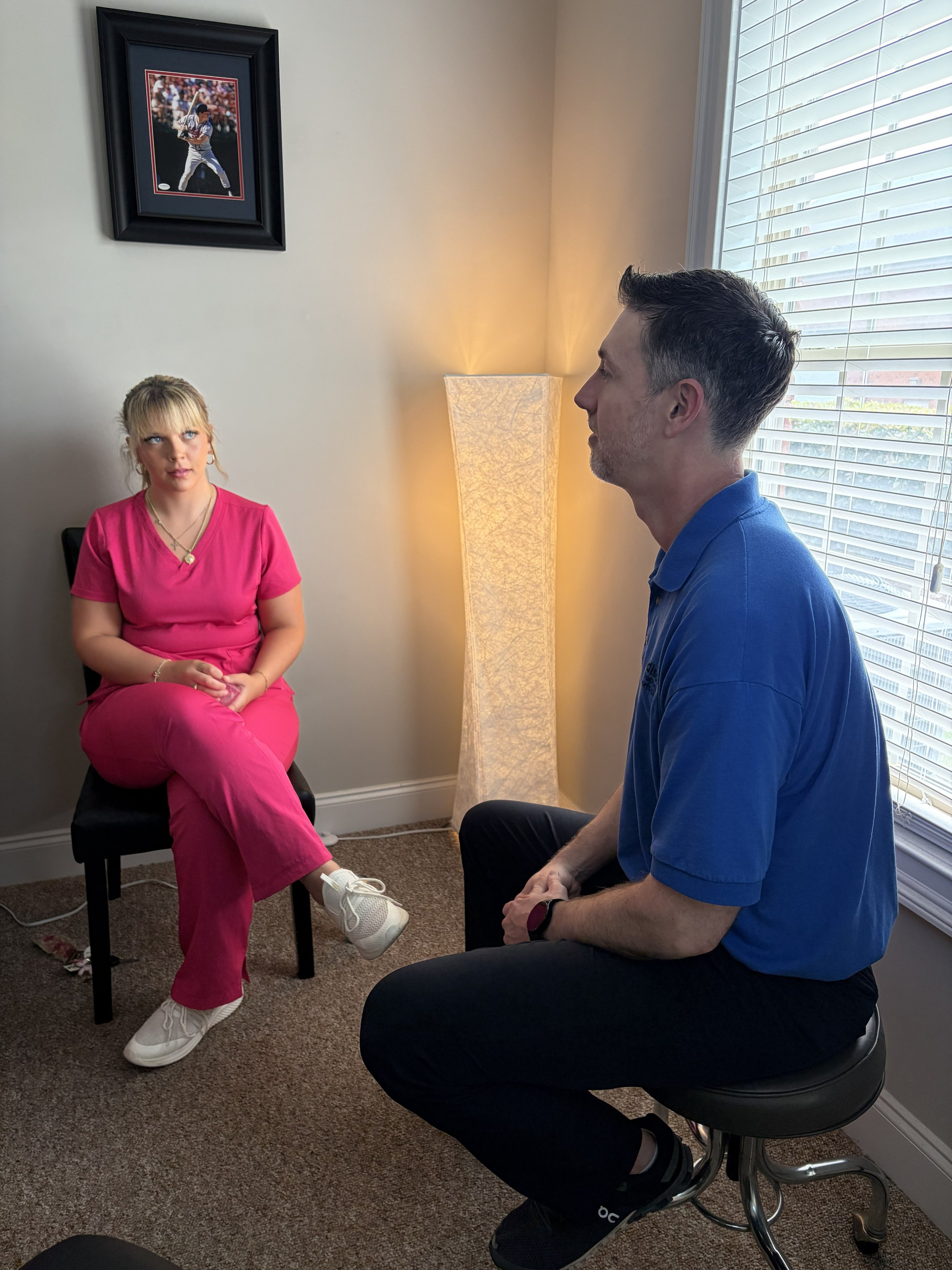 Dr. Jason Addison consulting with a patient at Addison Chiropractic & Sports Clinic, Kennesaw GA