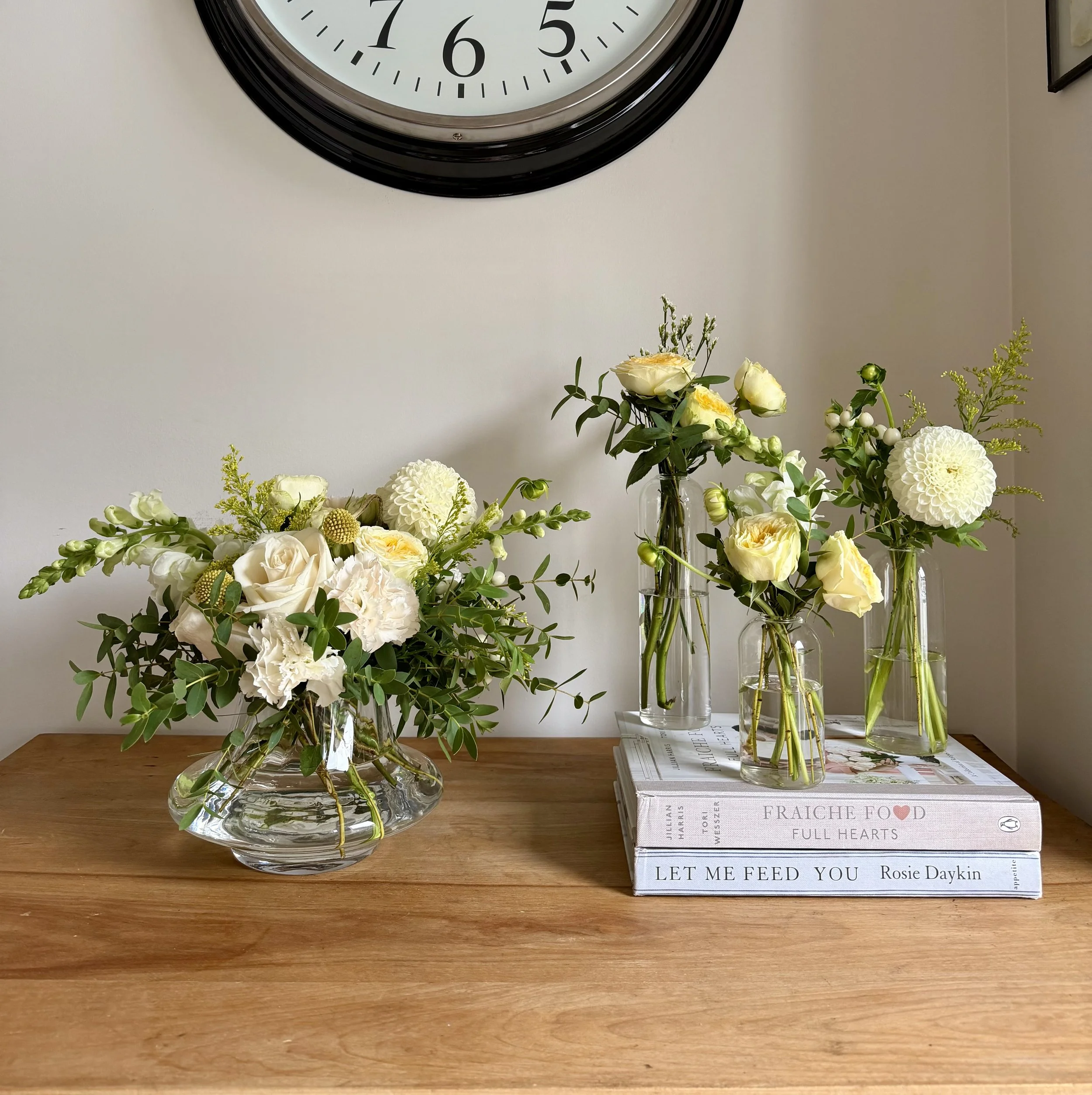 Floral arrangement in glass vases on a wooden surface.